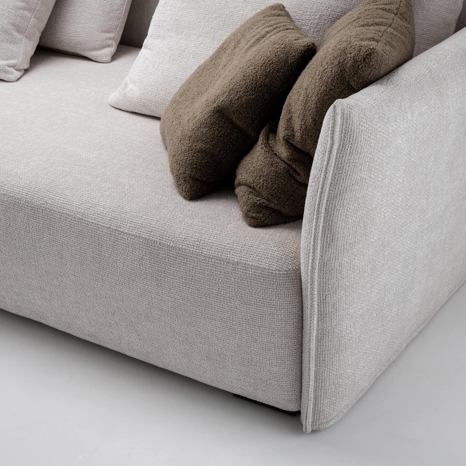 Luxurious beige fabric sofa with plush throw pillows, stylish and comfortable for modern living spaces.