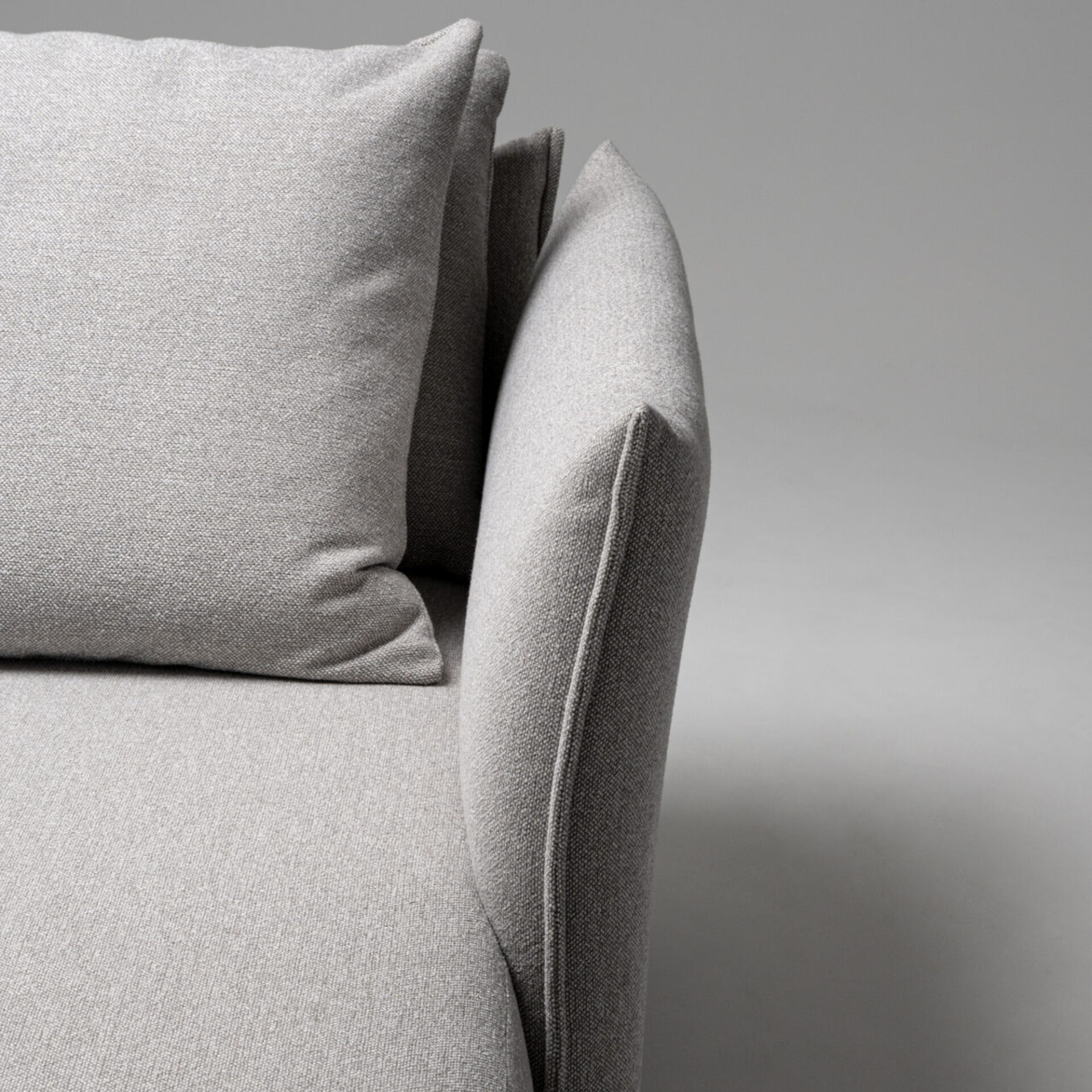 Luxurious light gray upholstered sofa with plush cushions and sleek modern design.