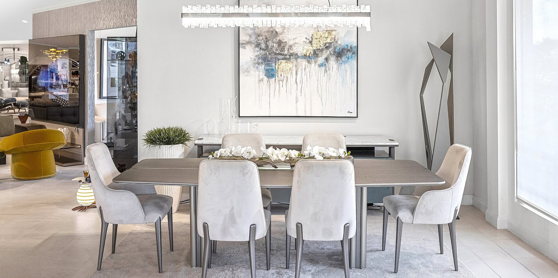 Contemporary dining room with sleek table and plush chairs, showcasing modern furniture design.