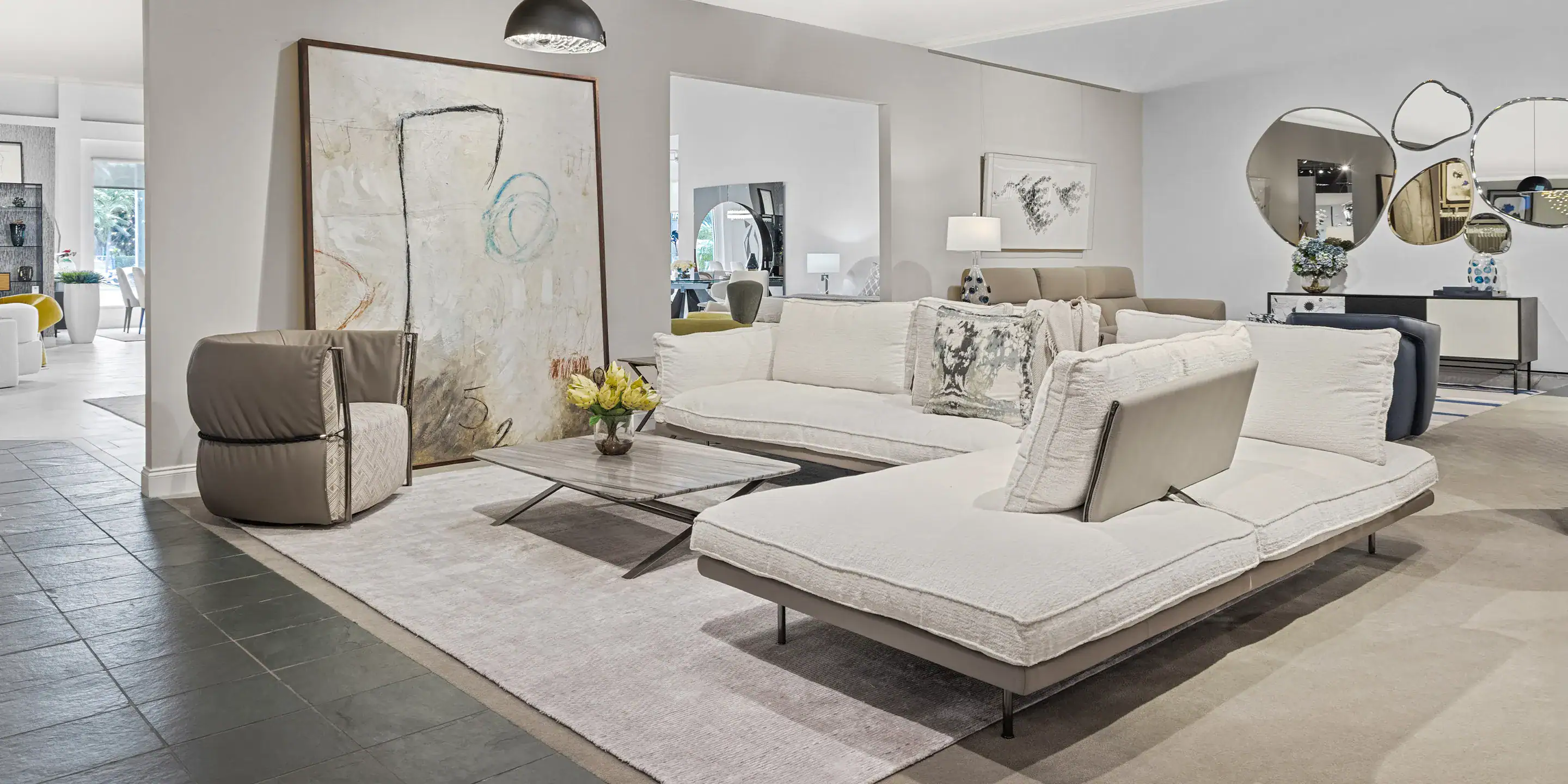 Contemporary living room with modern sofas, artwork, and stylish decor, showcasing premium furniture from Sklar Furnishings.