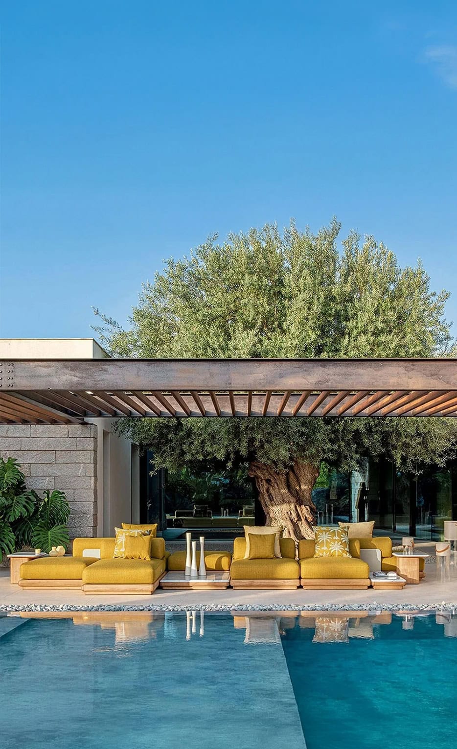 1. Modern outdoor seating with yellow cushions under a pergola near a pool.
