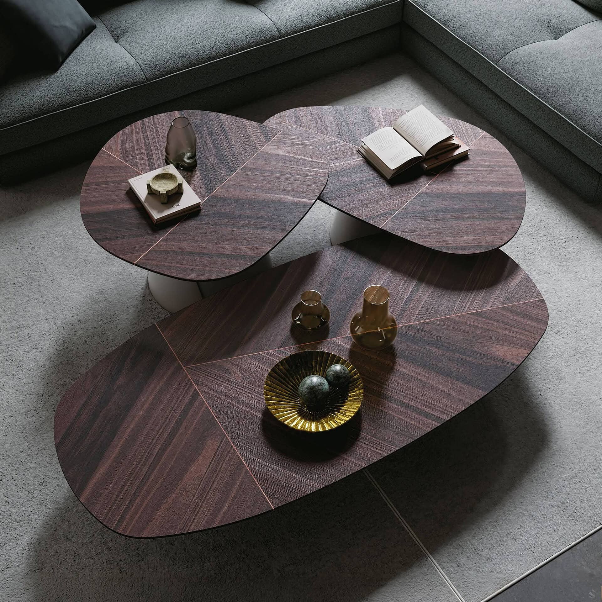 Sleek modern wooden coffee tables with unique oval shapes and decorative accessories in a contemporary living room.