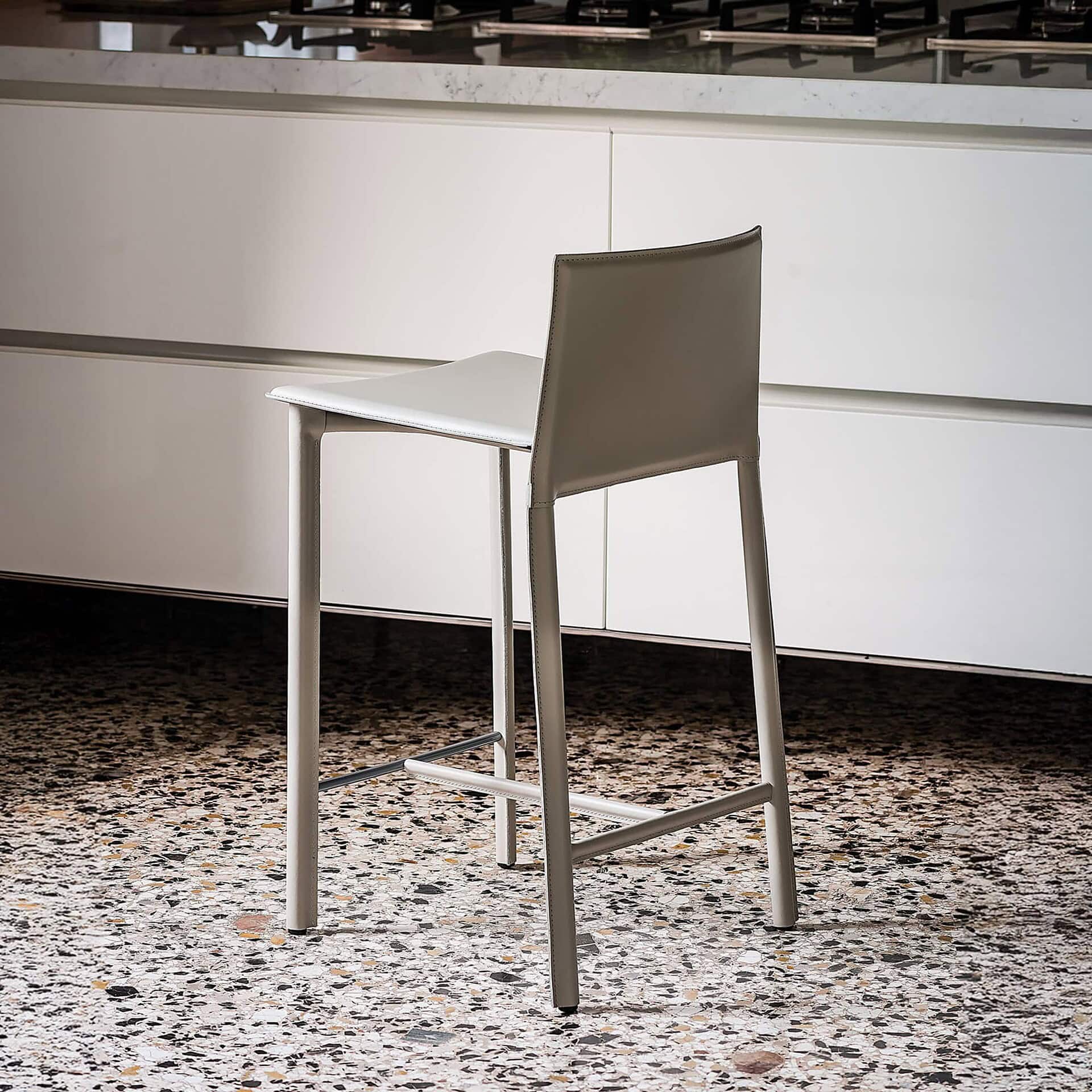 Cliff Stool in leather with slim, minimalist silhouette, placed in a contemporary kitchen setting.