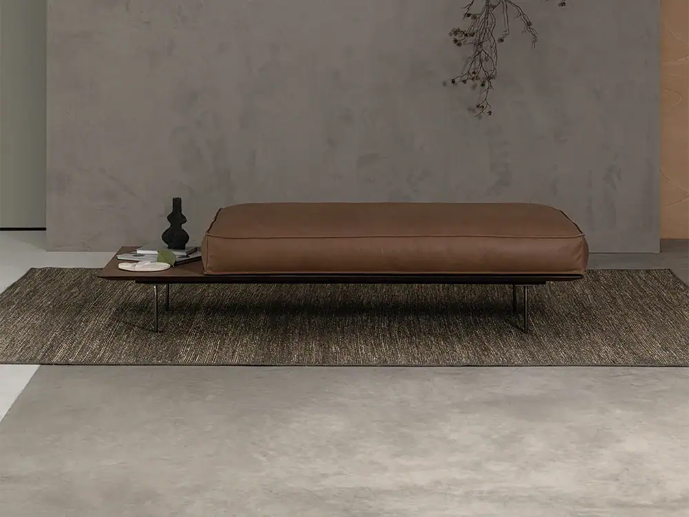 Modern leather bench with side table in minimalist interior design.