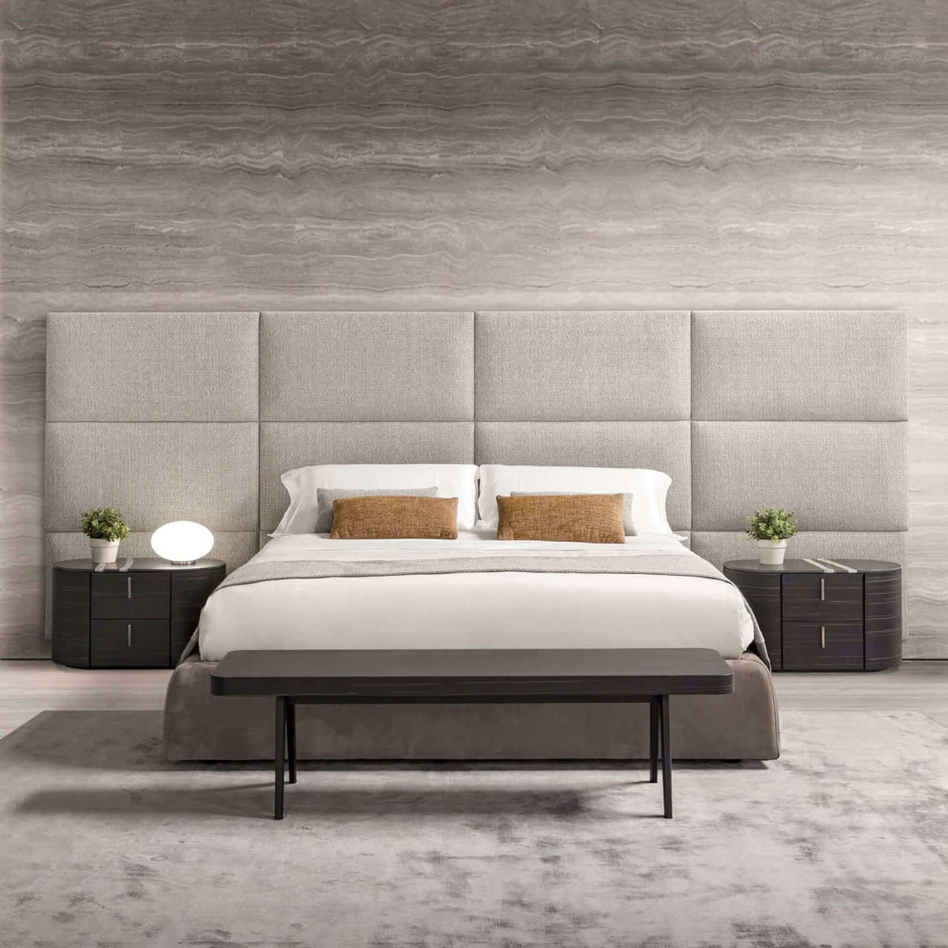 Elegant beige upholstered bed with a modern headboard and sleek nightstands for luxury bedroom decor.