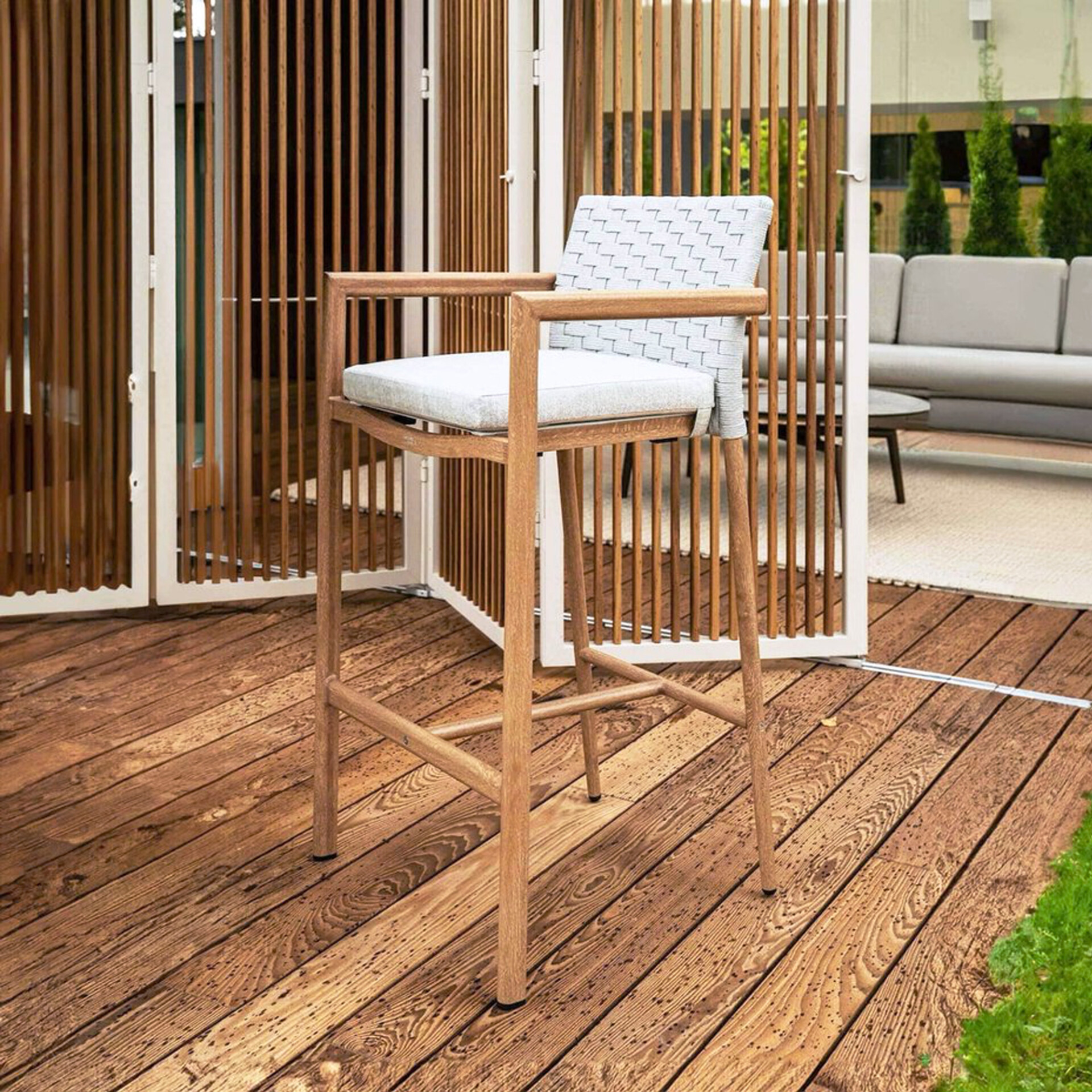Outdoor bar setting with Lounge Bar Stools and round bar tables on a patio overlooking the ocean.
