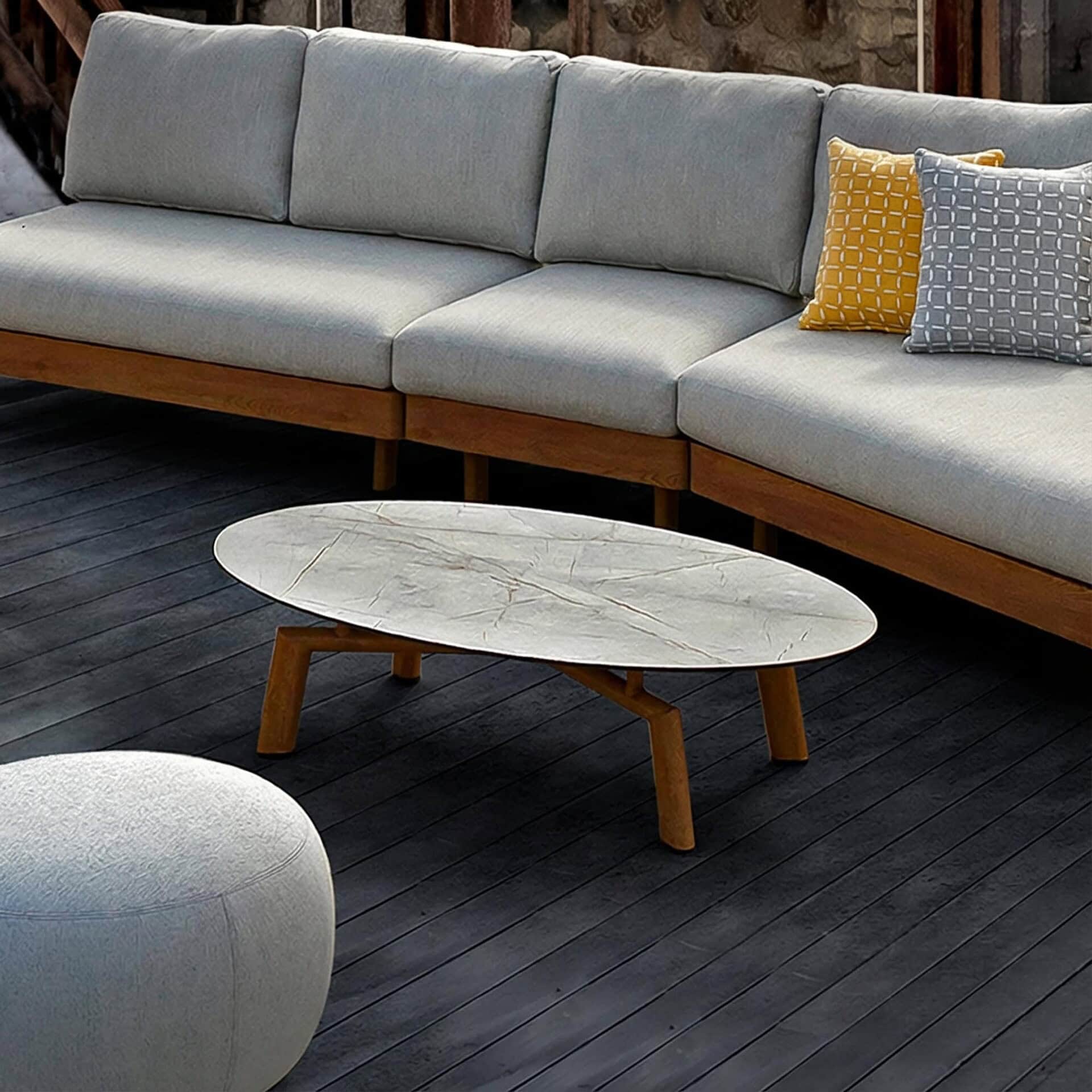 Modern outdoor sofa with neutral cushions and a sleek coffee table on a stylish patio.