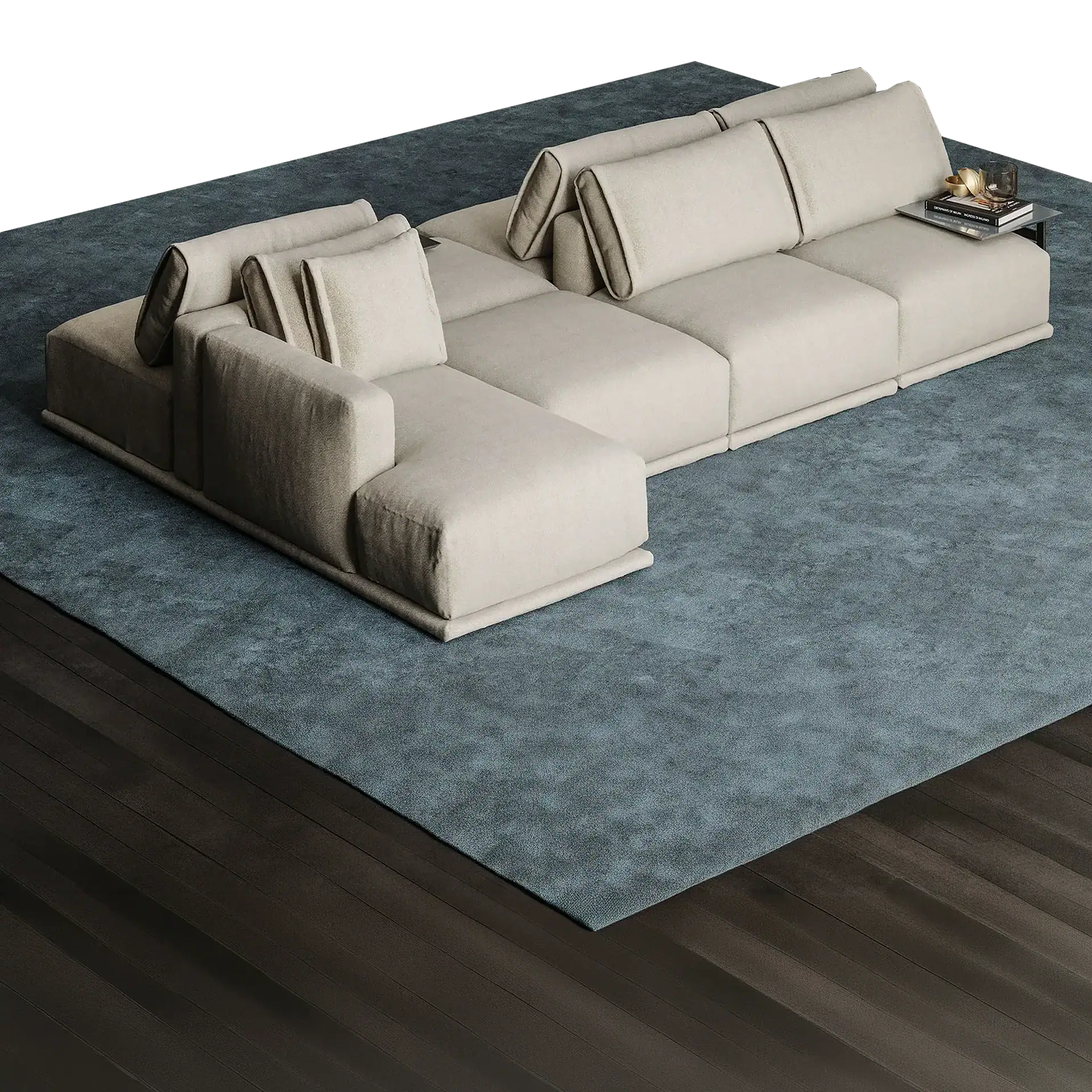 A large, light beige modular L-shaped sofa with adjustable backrests sits on a dark teal textured rug, with dark wooden floorboards visible around it. A small glass table on the sofa holds books and decorative items.