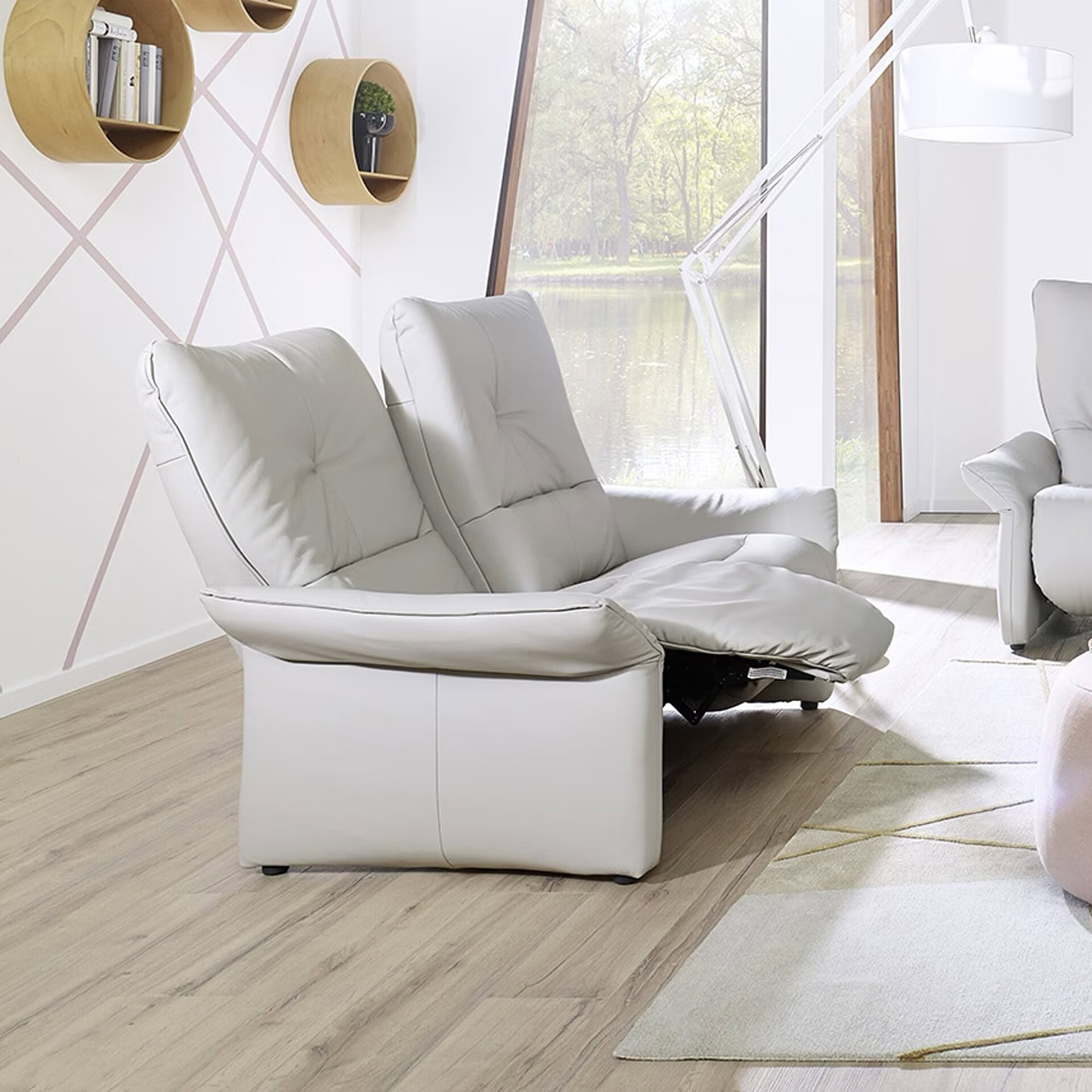 White leather sofa with adjustable headrests in modern living room.