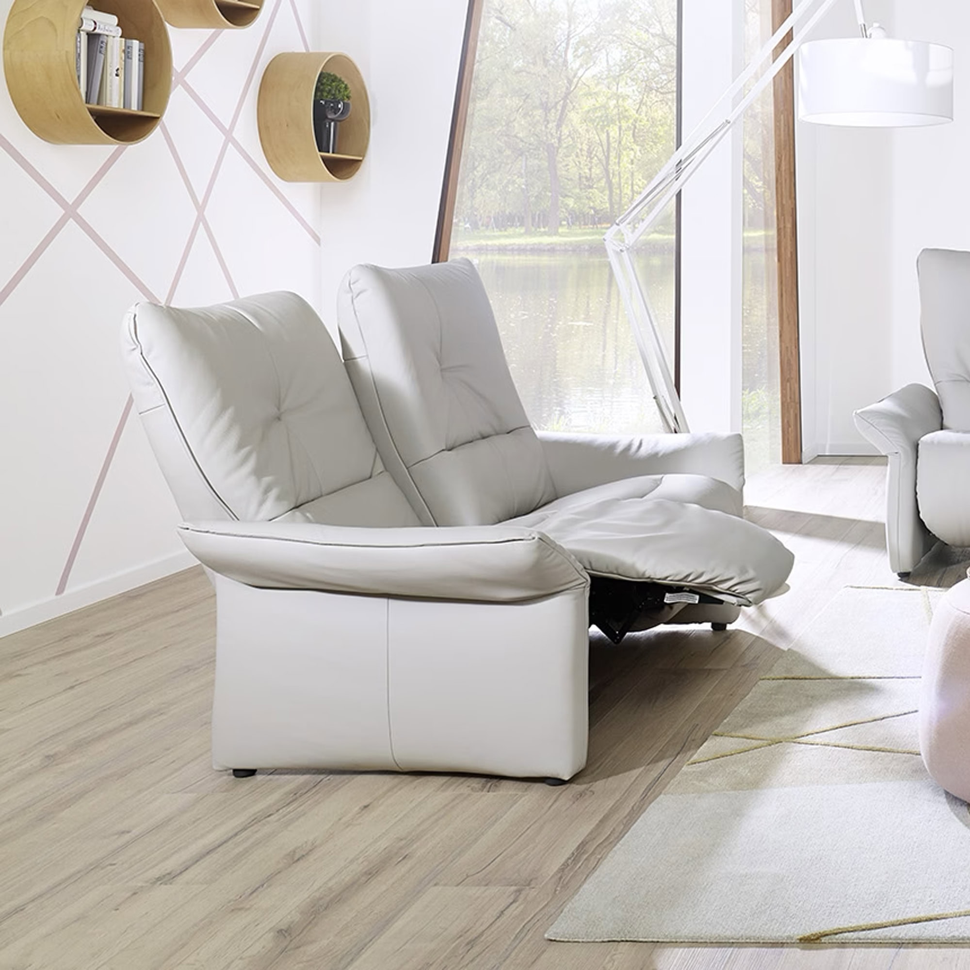 White leather sofa with adjustable headrests in modern living room.
