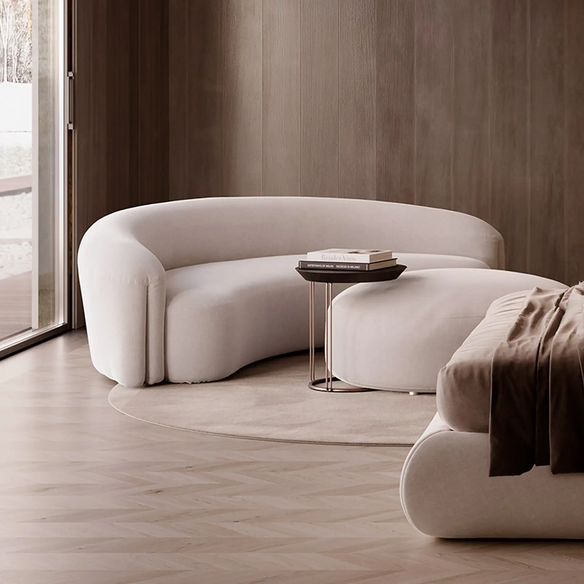 A modern living room with floor-to-ceiling windows showing a city view. Two curved taupe sofas and a round ottoman sit on a grey rug. A sculptural lamp and abstract art are also visible.