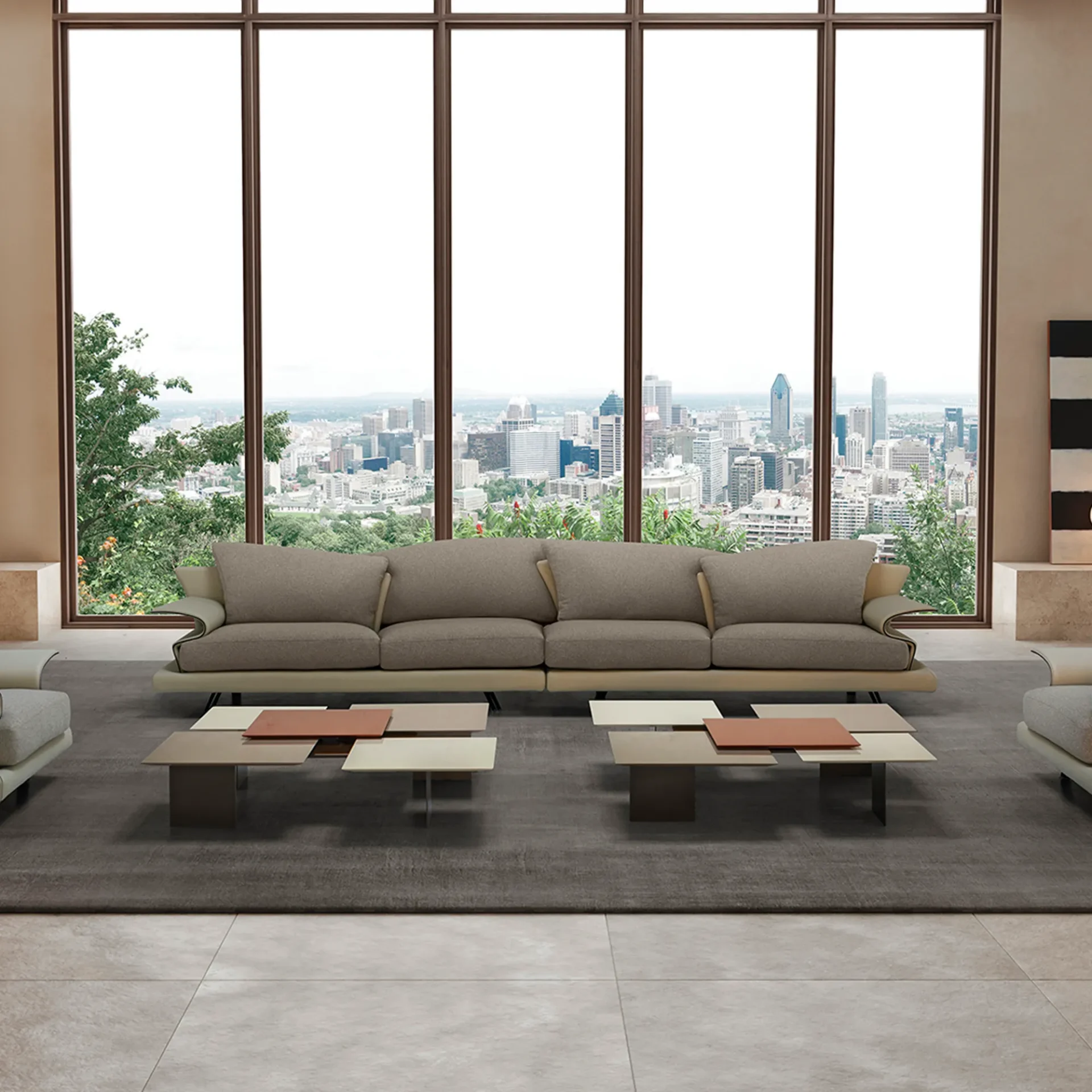 A modern living room with a long taupe sofa and two multi-level coffee tables, facing a large window that overlooks a sprawling city skyline with green trees in the foreground.