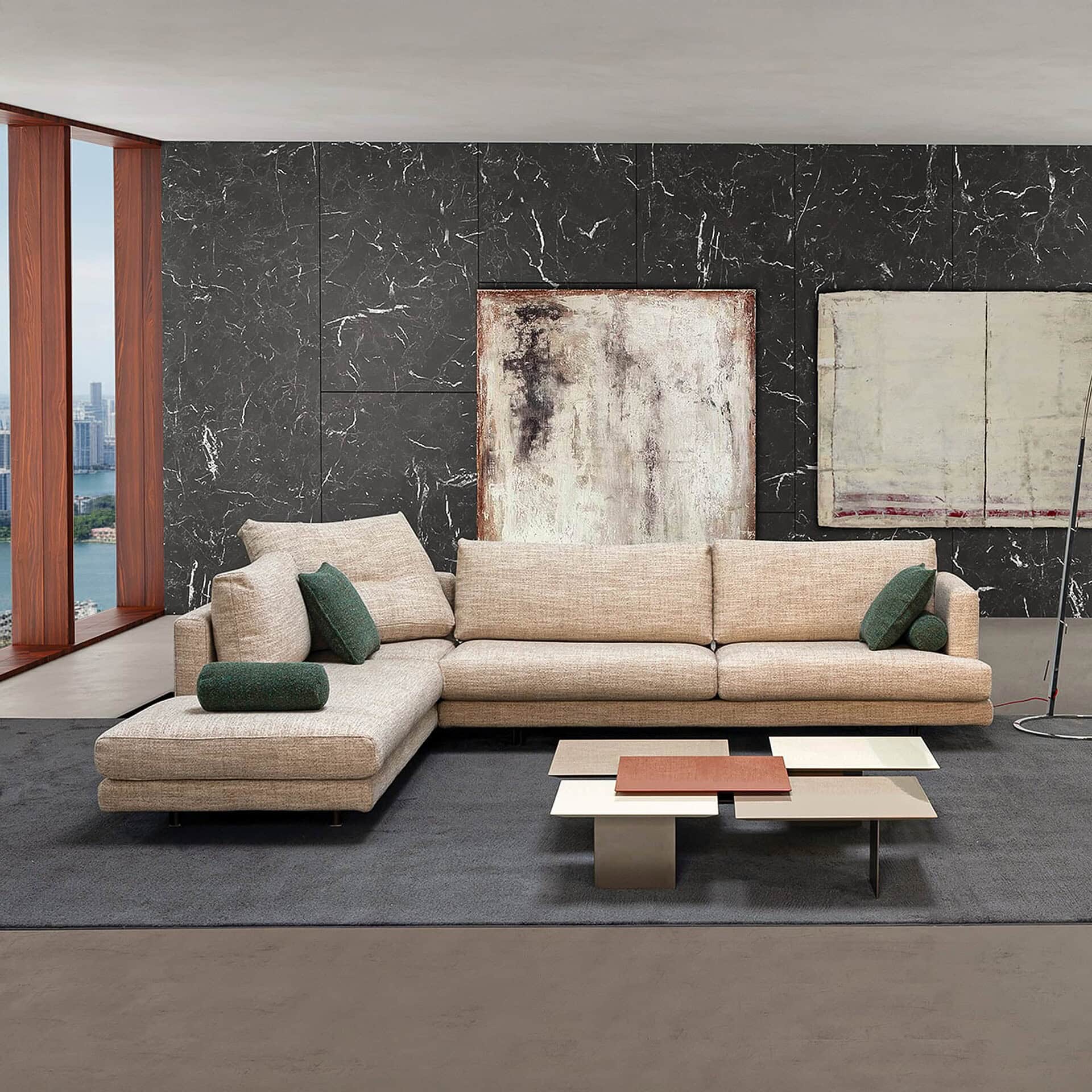 Contemporary beige sectional sofa with green accent pillows in modern living room.