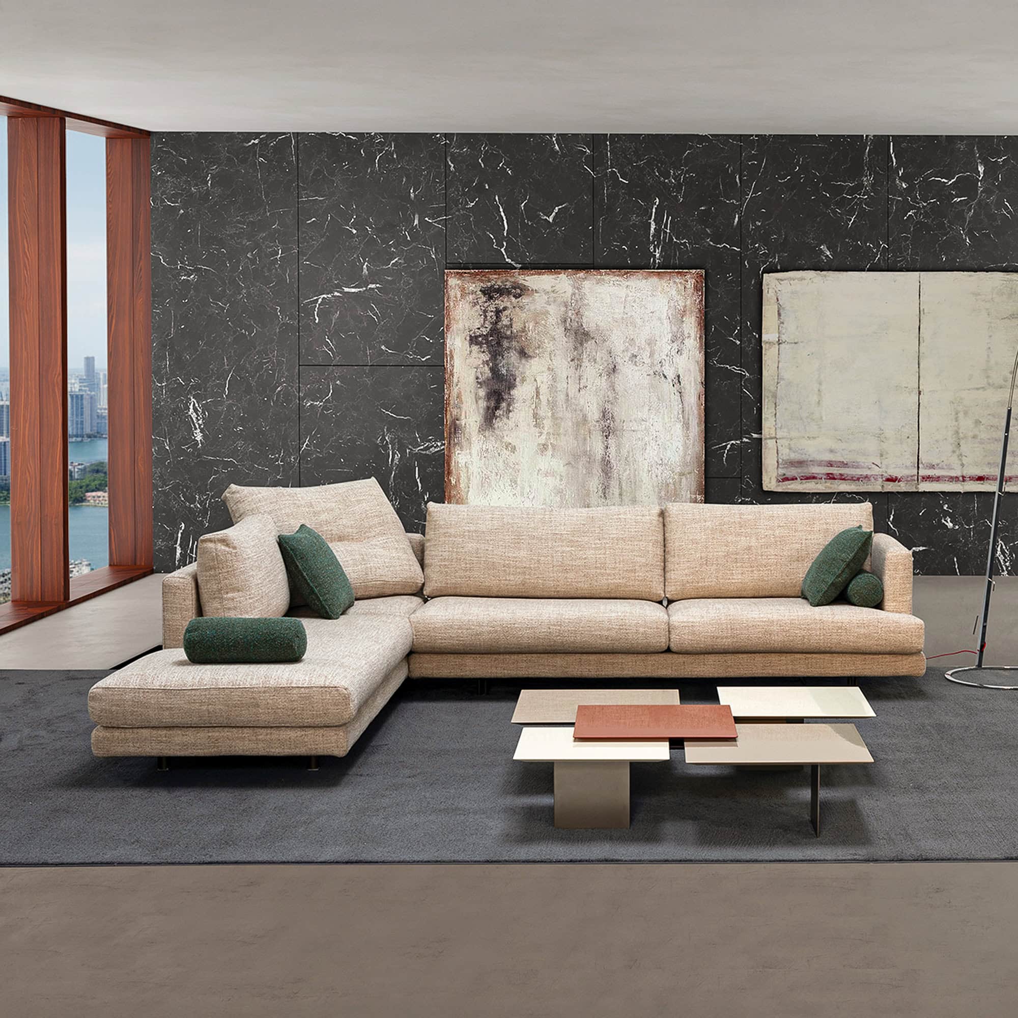 Contemporary beige sectional sofa with green accent pillows in modern living room.