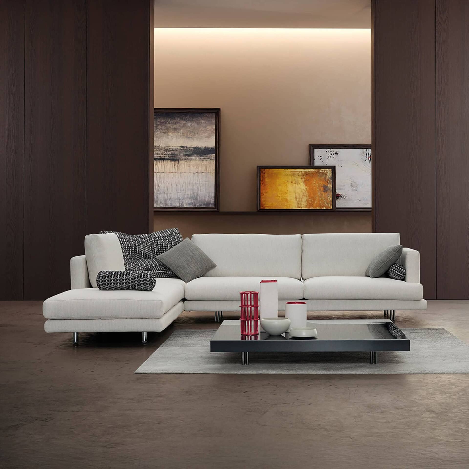 Luxury modern white sectional sofa with decorative cushions in contemporary living room.