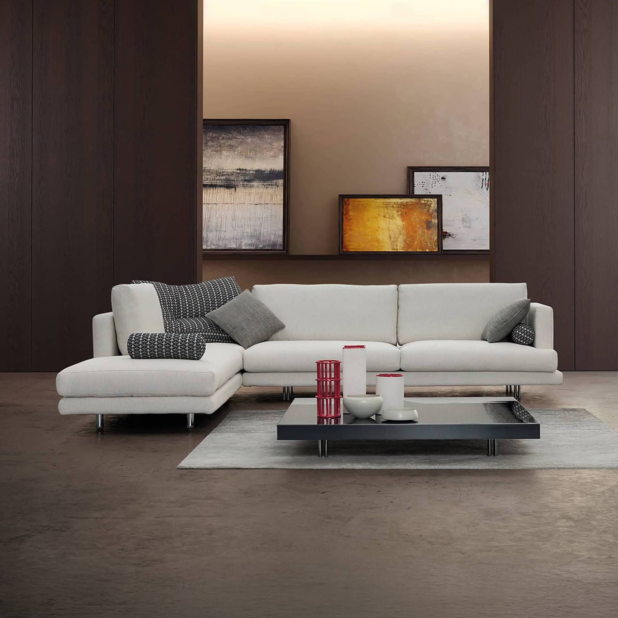 Luxury modern white sectional sofa with decorative cushions in contemporary living room.