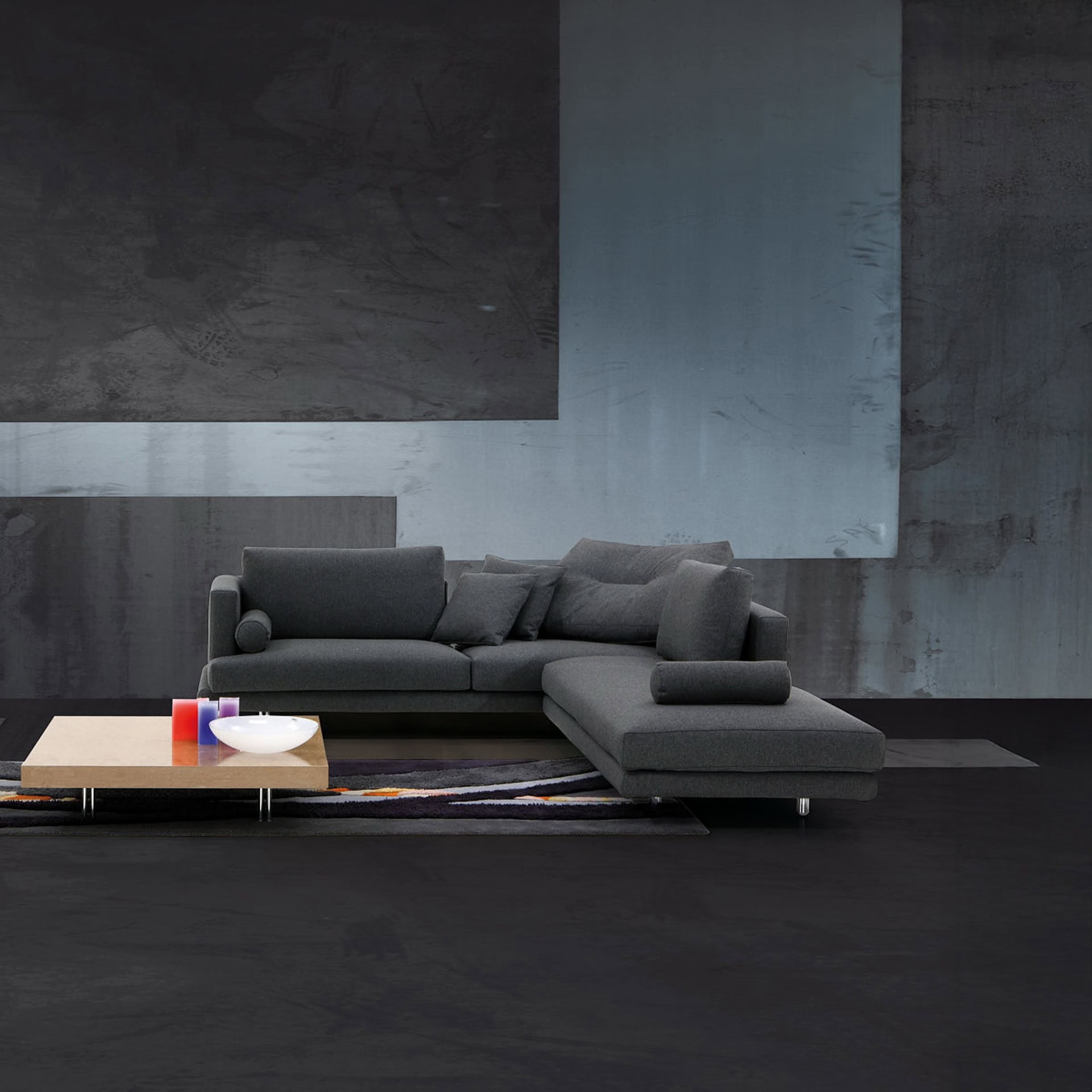 Contemporary gray sectional sofa with plush cushions in a modern living room setting.