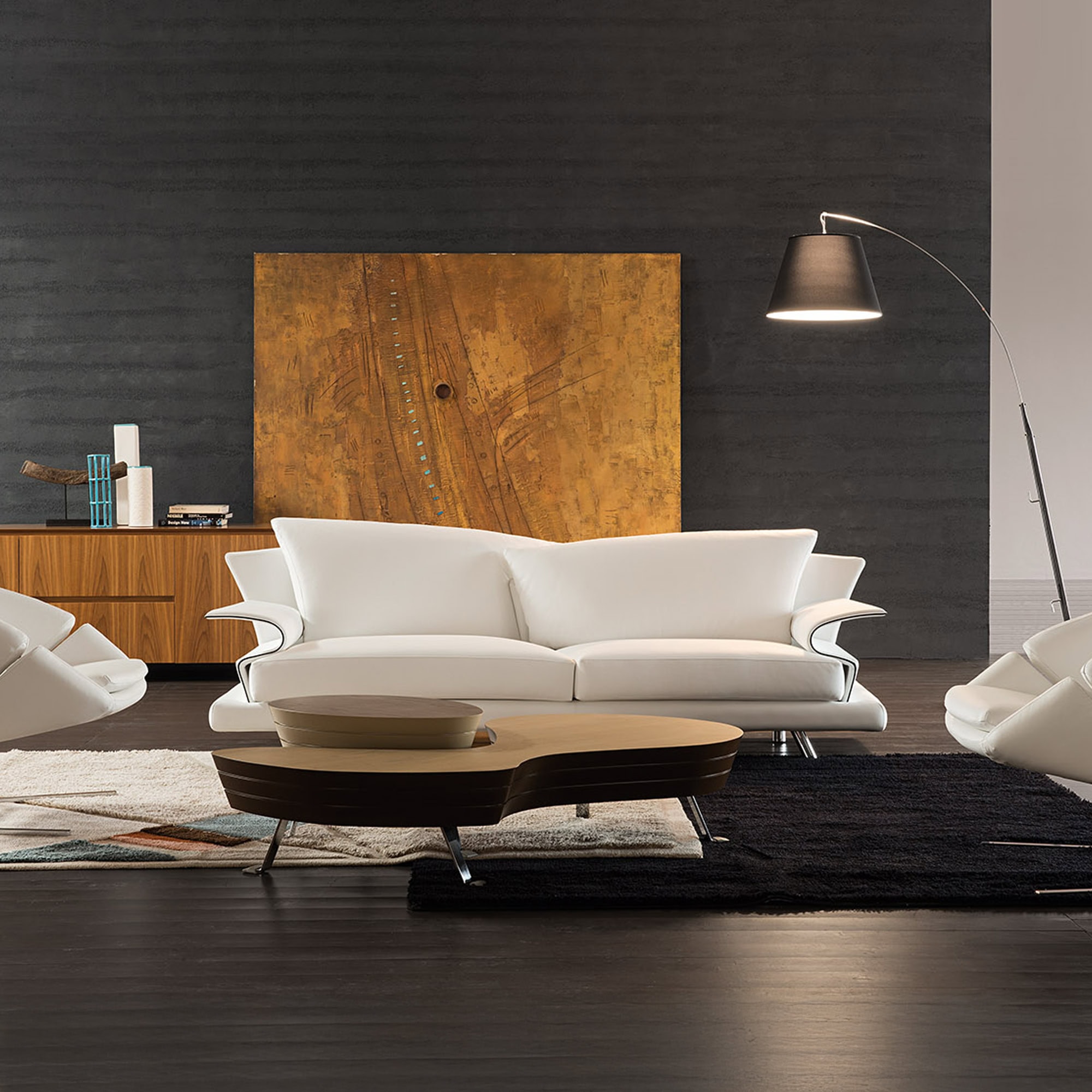 Elegant modern living room with white leather sofas, wooden coffee table, and contemporary lighting in a stylish setting.
