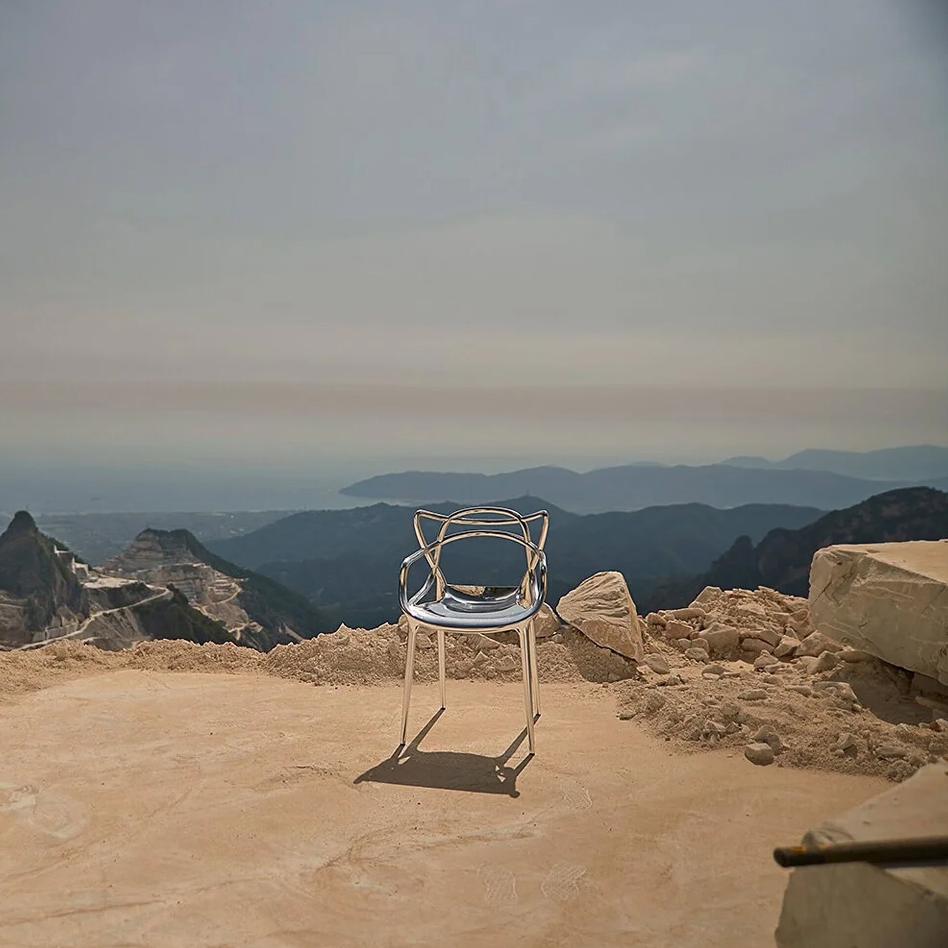Masters Metal Dining Chair placed outdoors on a rocky mountain landscape with open sky backdrop.