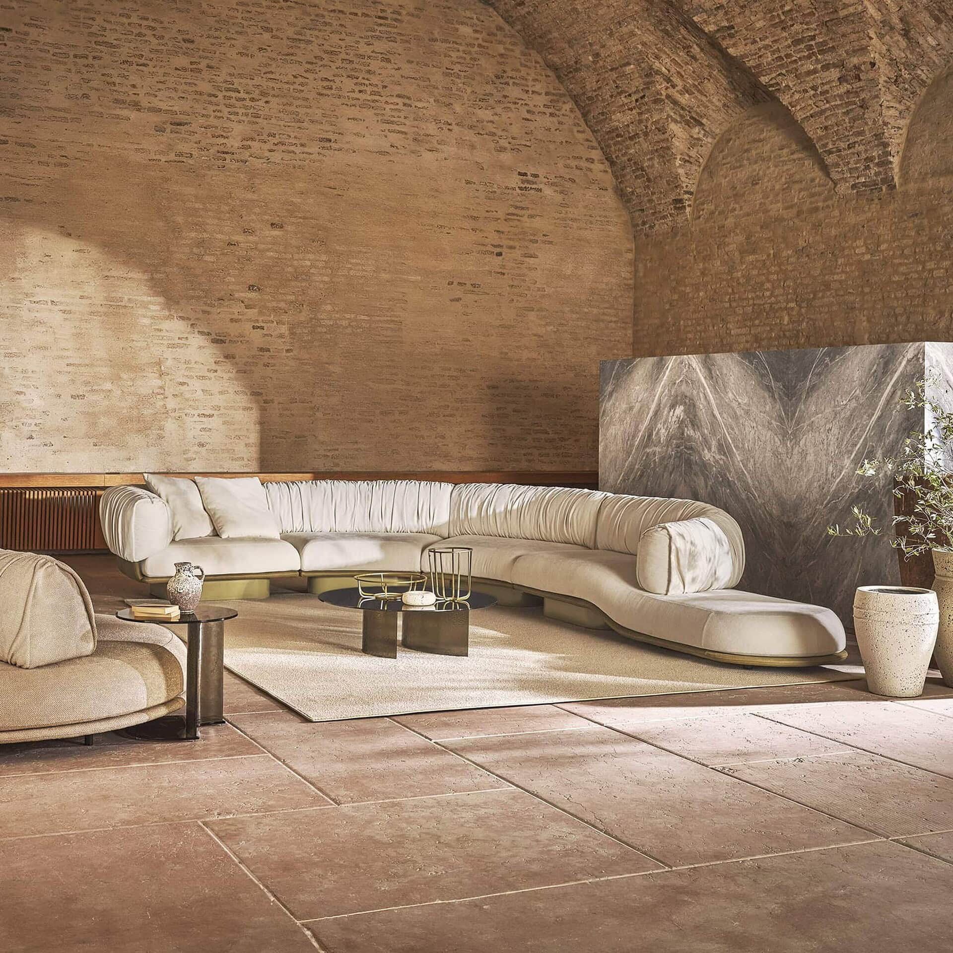 Luxurious modern sectional sofa in a sophisticated, minimalist living space with earthy tones and elegant decor.