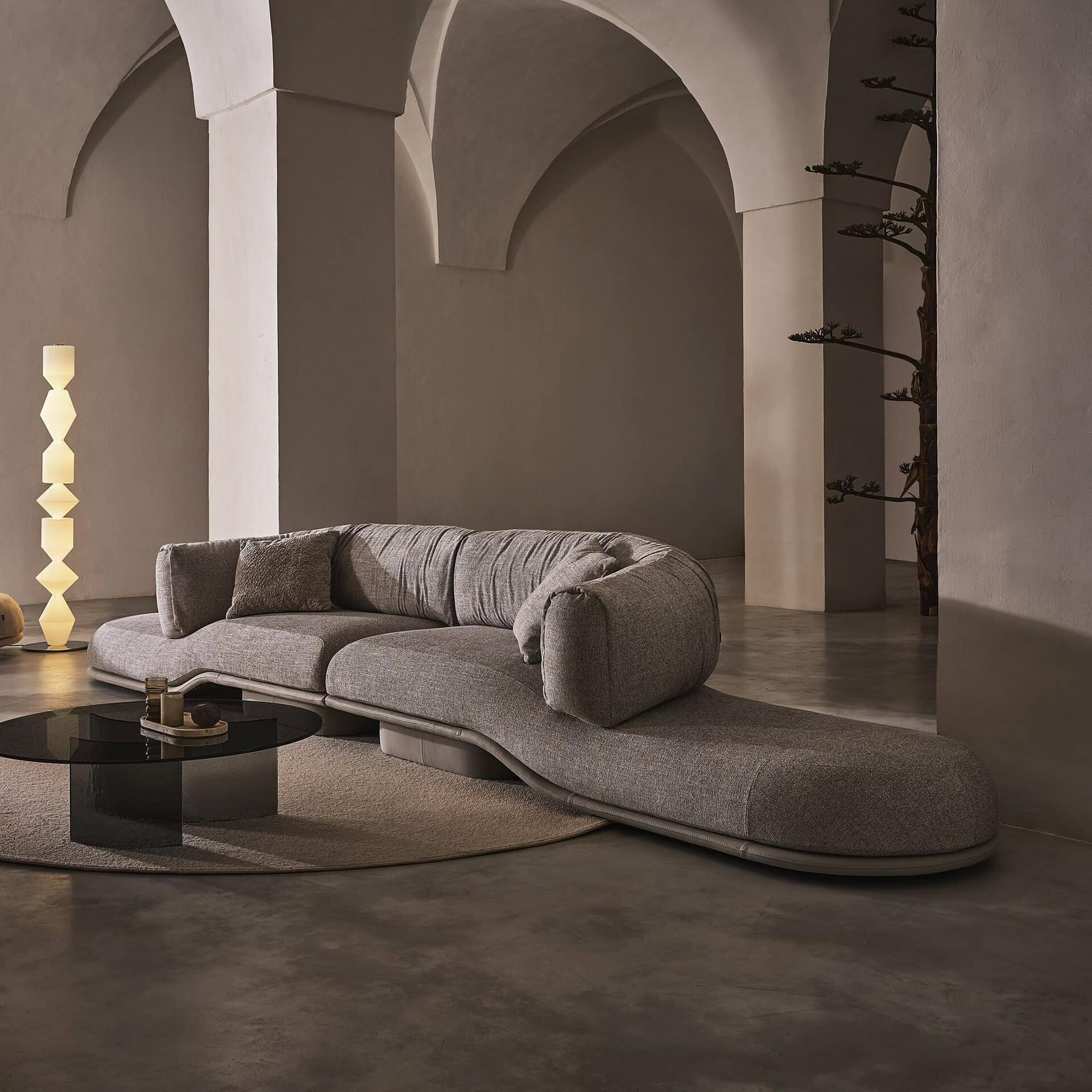 Luxury modern sectional sofa in neutral gray fabric with unique curvilinear design, perfect for stylish living rooms.