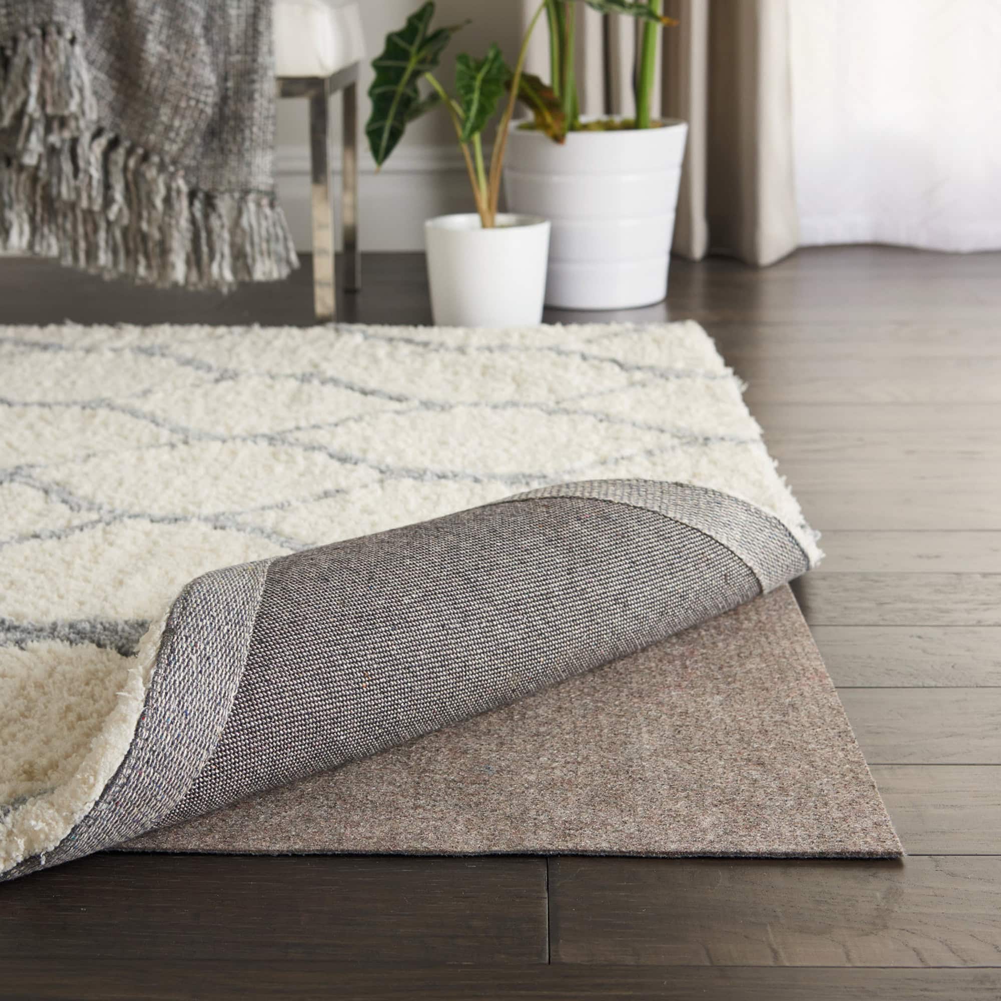 Grey Rug-Loc Basic BR21 rug pad shown beneath an area rug on hardwood floor, providing a secure and cushioned base.