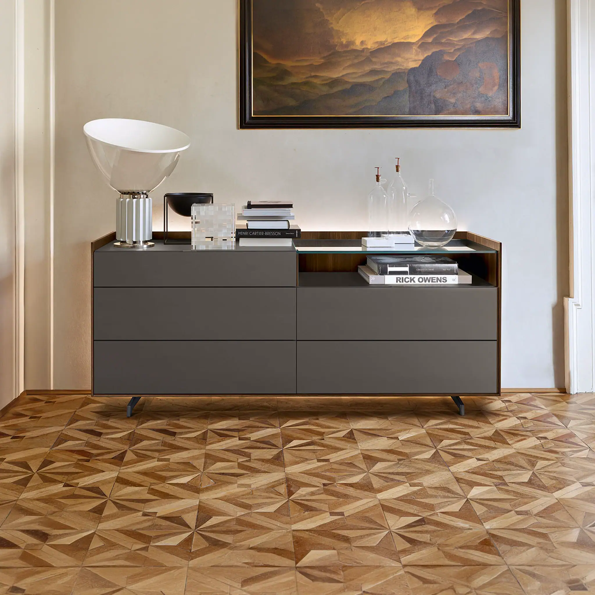 Modern gray sideboard with decorative items and artwork in a stylish interior setting.