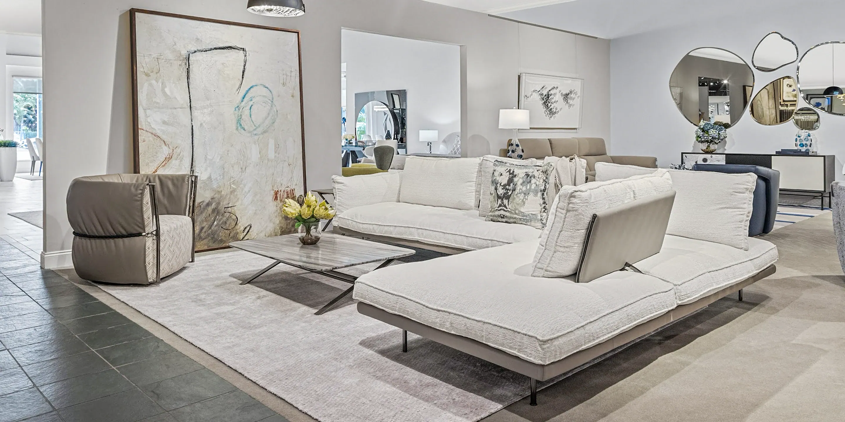 showroom-vignette-apr-25-living-room Contemporary living room with modern sofas, artwork, and stylish decor, showcasing premium furniture from Sklar Furnishings.