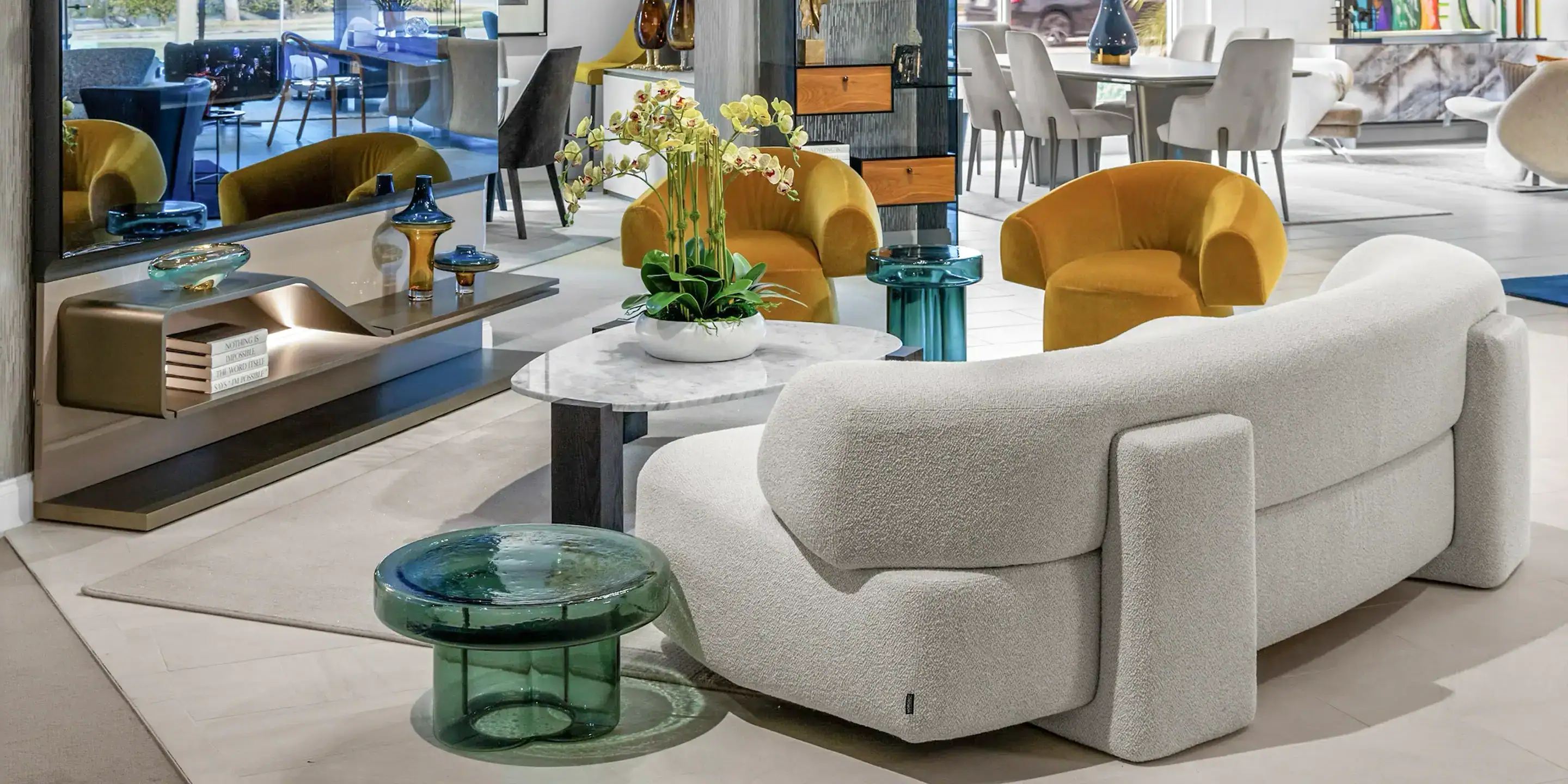 Sklar Furnishings modern living room with curved light gray sofa and yellow chairs.