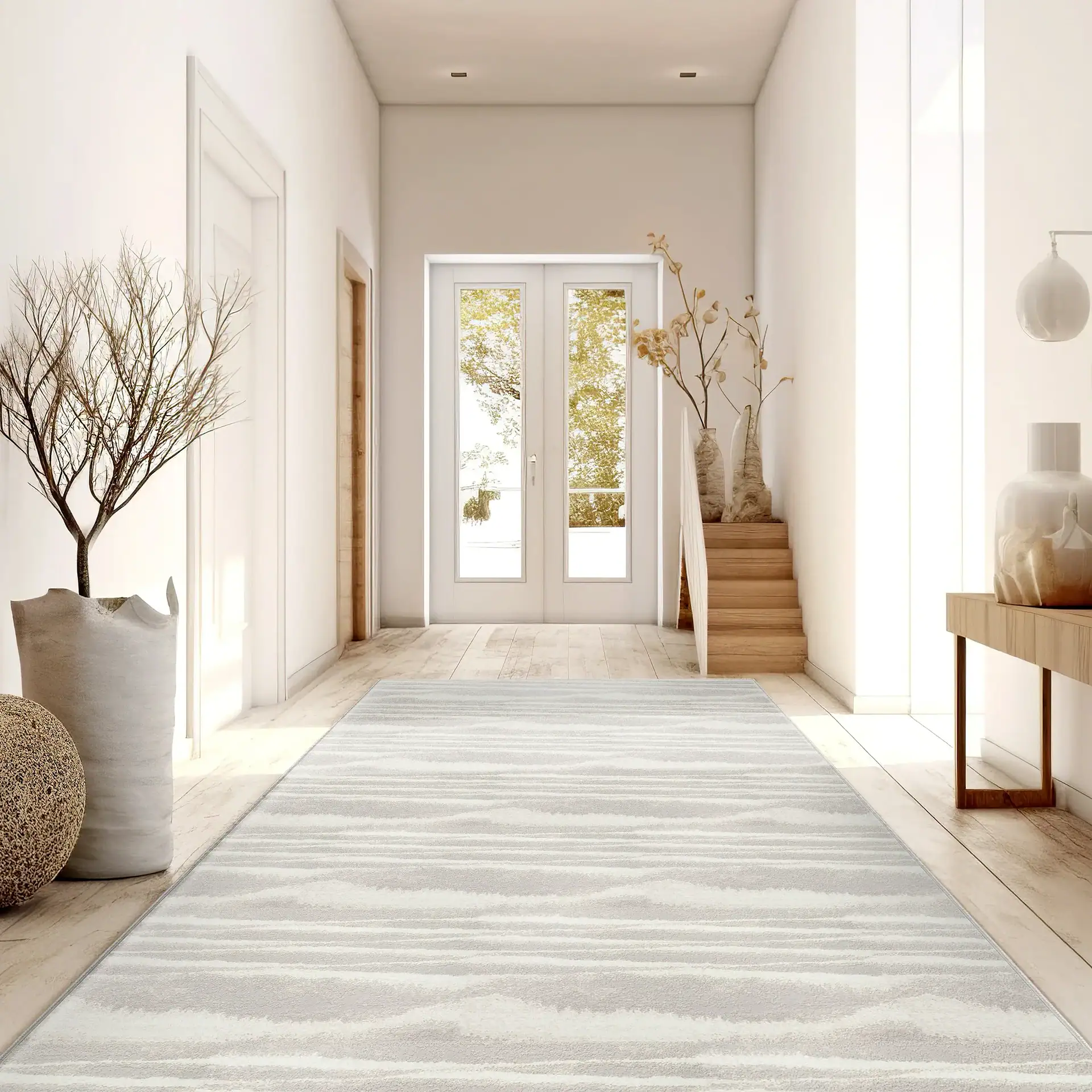 Entryway with minimalist design, featuring natural decor, light wood stairs, and large glass doors.