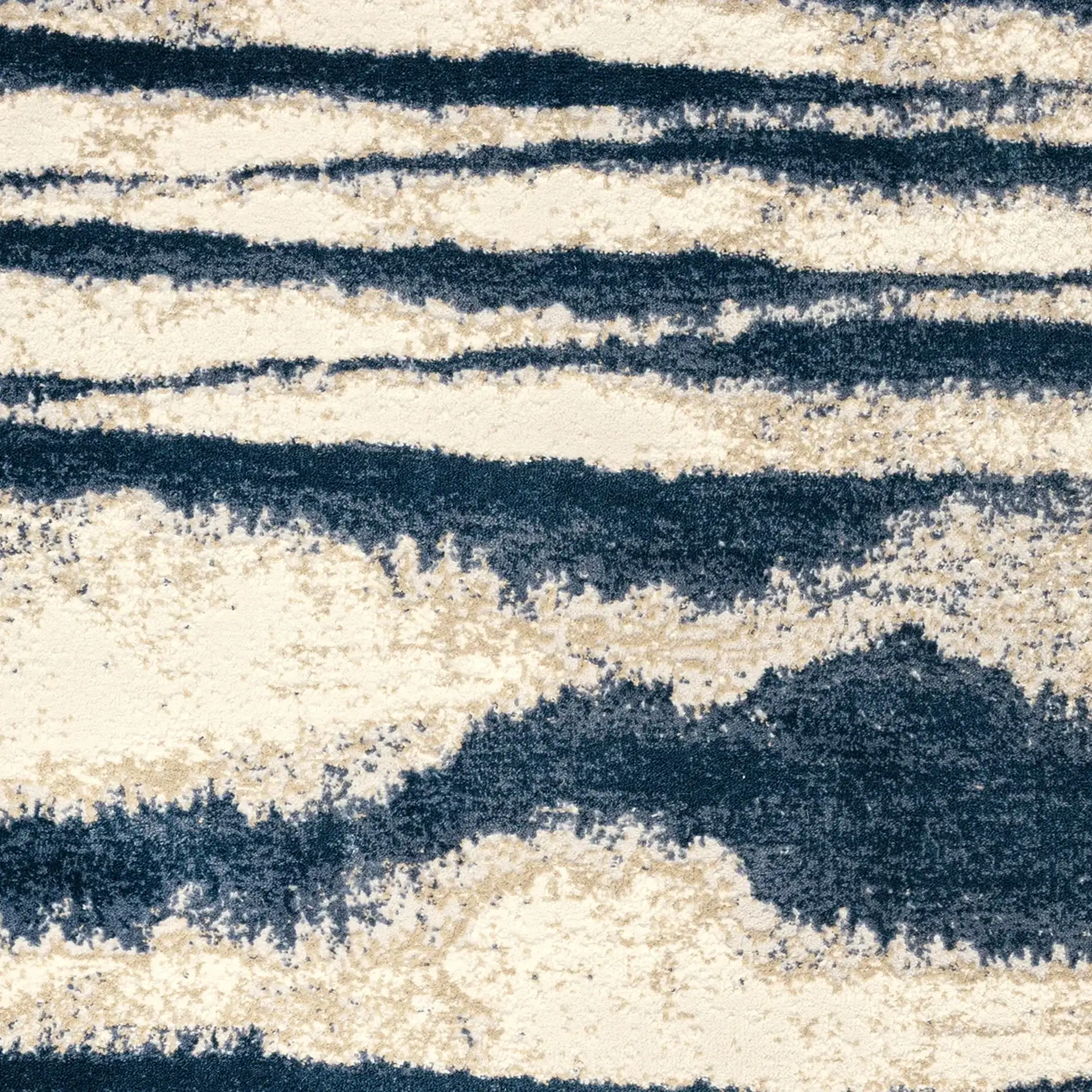 Close-up of textured beach sand with ocean waves in the background.