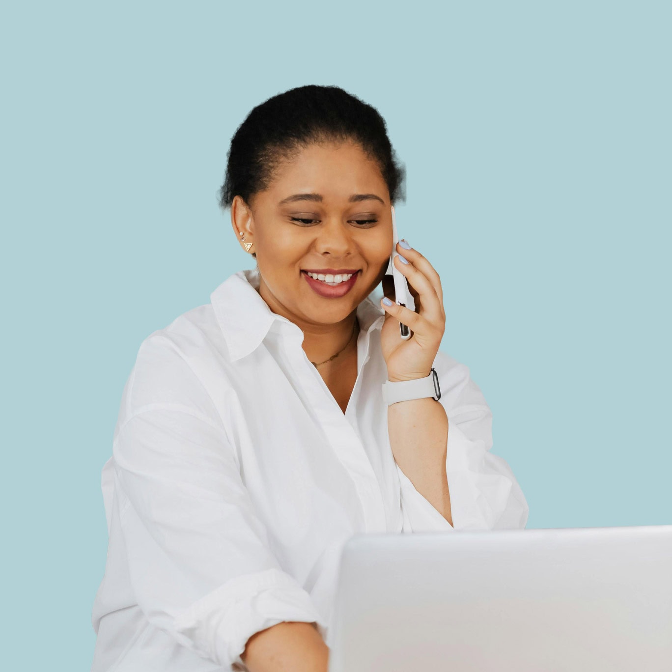 Elegant woman using a smartphone with laptop, showcasing modern office or home office furniture.