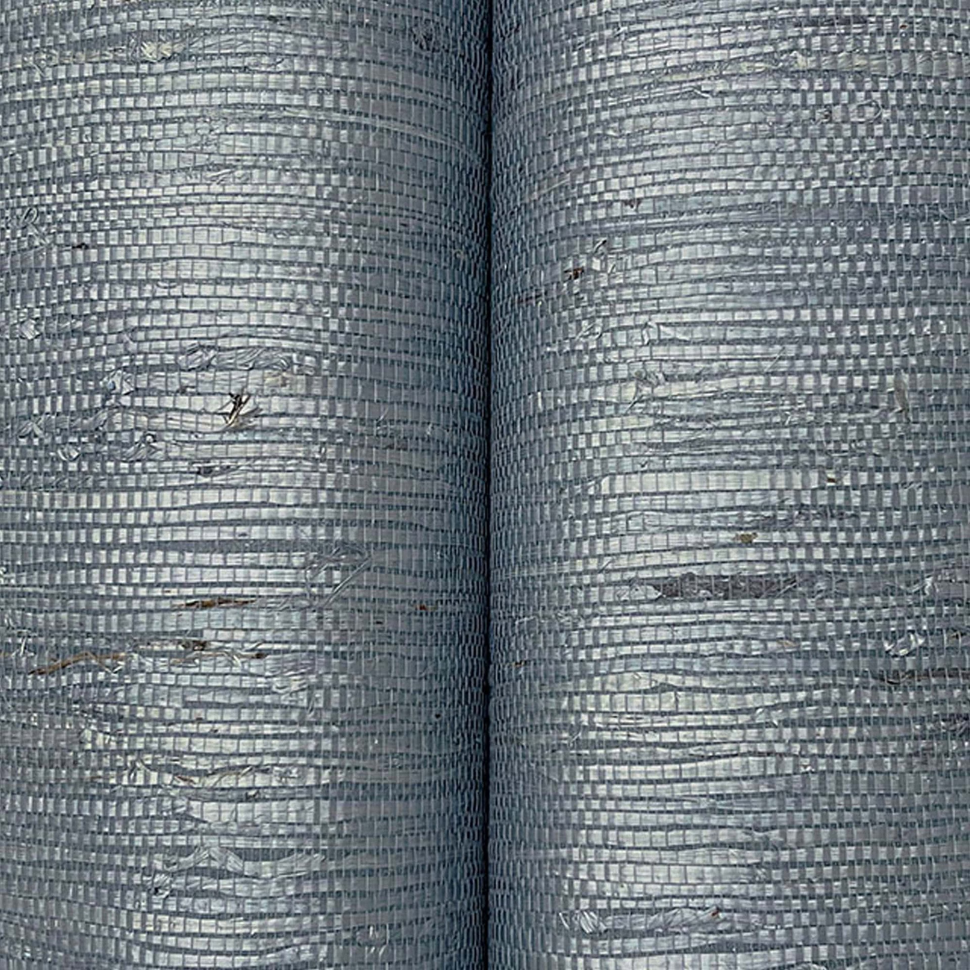 Rolled view of Oceanside Grey Mist Grasscloth Wallpaper highlighting the woven grasscloth material.