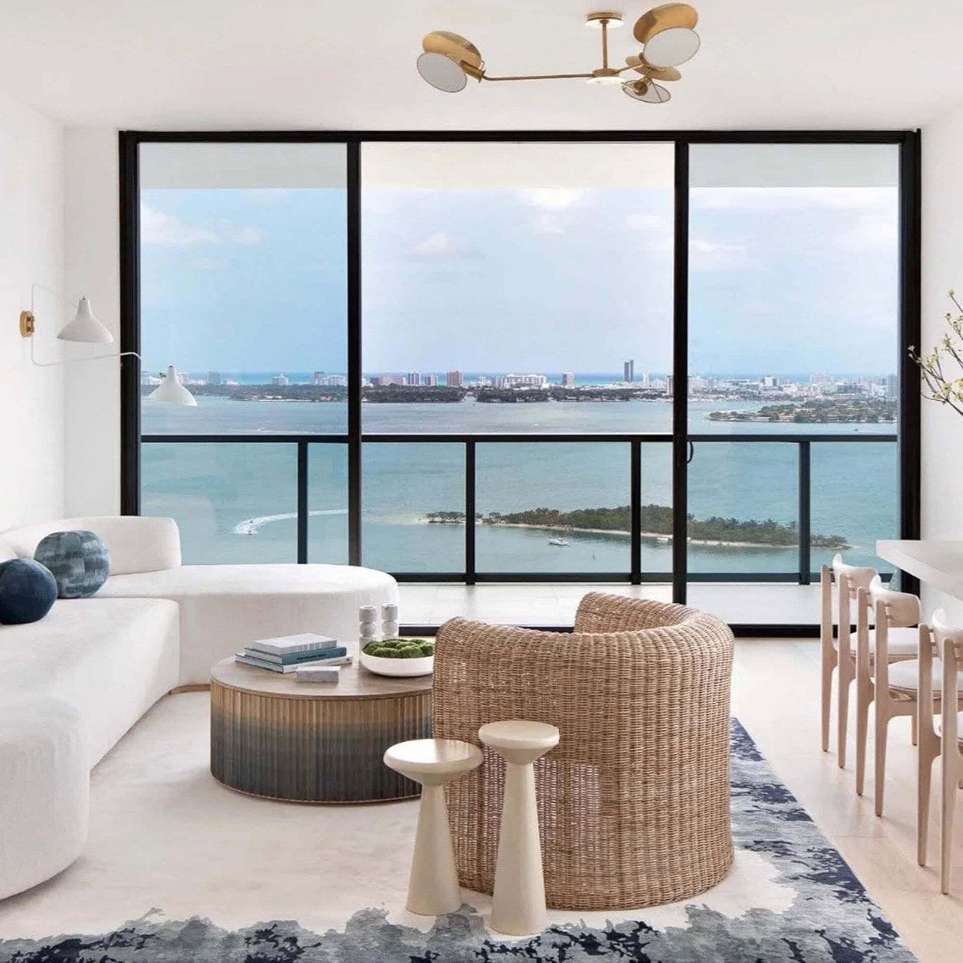 Contemporary living room with ocean views, modern furniture, and sleek design, showcasing luxury interior decor from Sklar Furnishings.