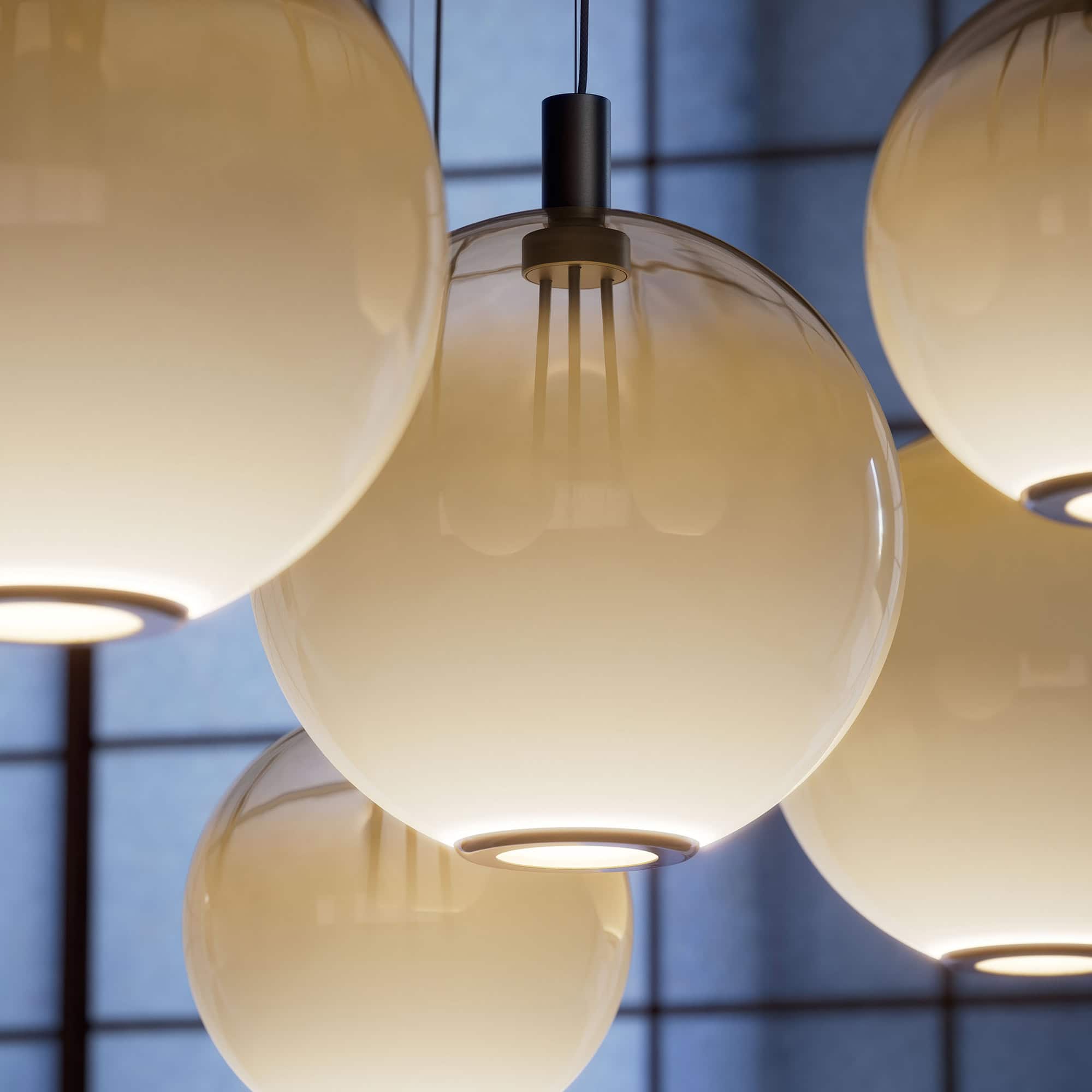 Elegant modern pendant light fixtures with frosted glass globes for contemporary interior design.