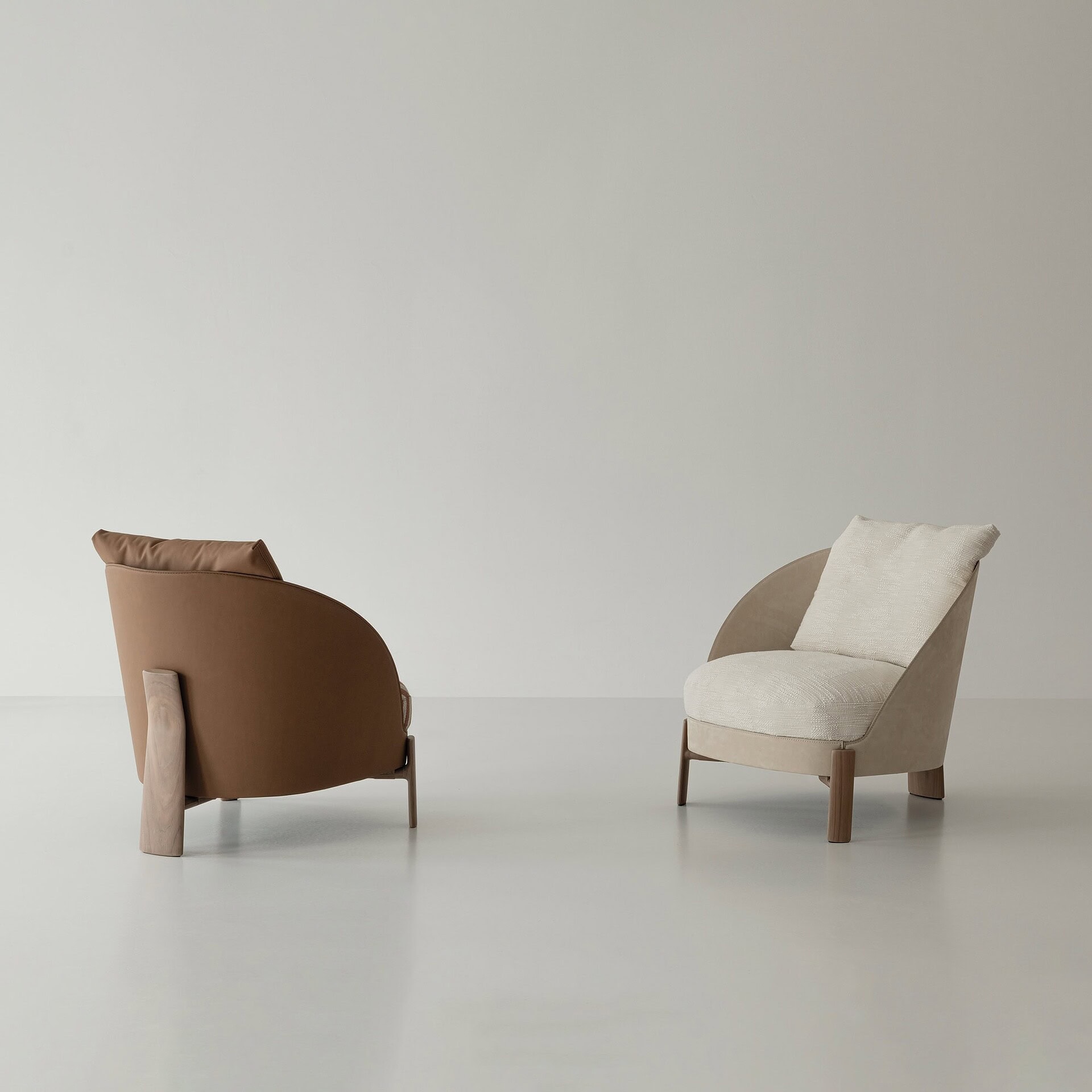 Contemporary modern armchairs with wooden legs, beige and brown upholstery, minimalist design.