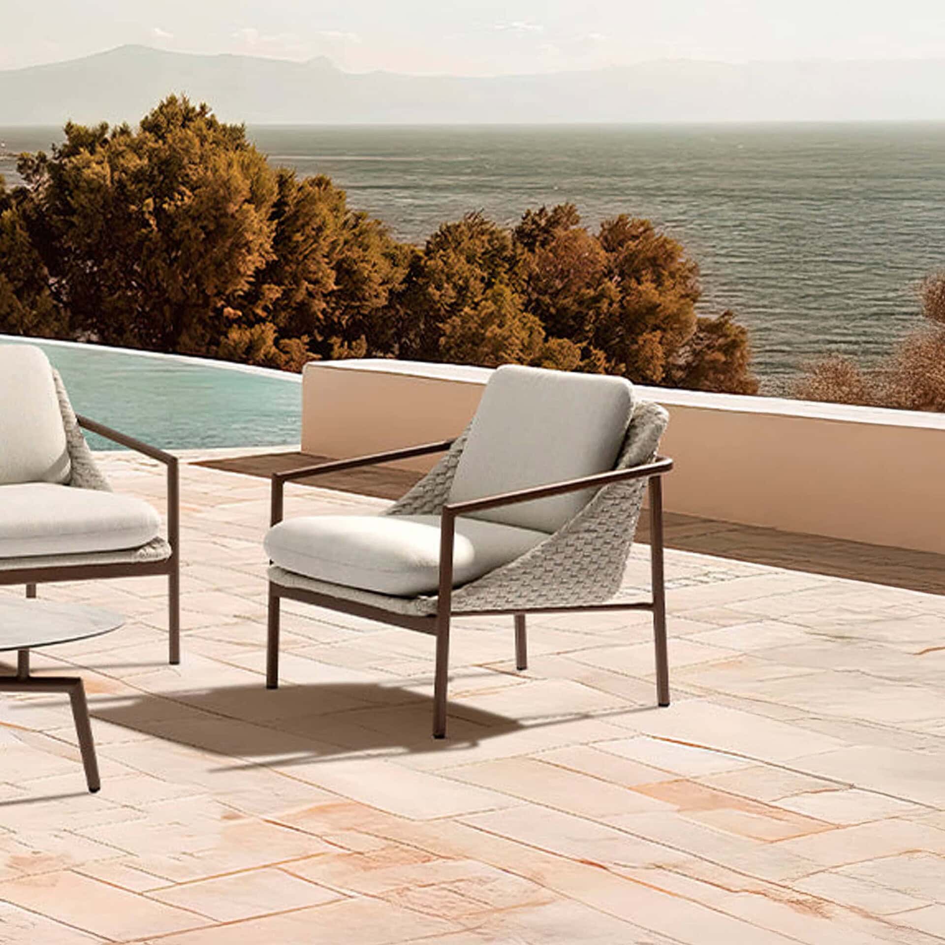 Modern outdoor lounge chair with woven side panels and neutral cushions on a wooden deck.