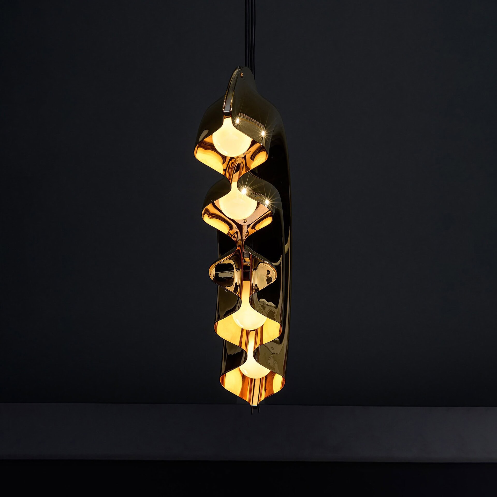 Elegant modern pendant chandelier with gold accents and warm lighting.