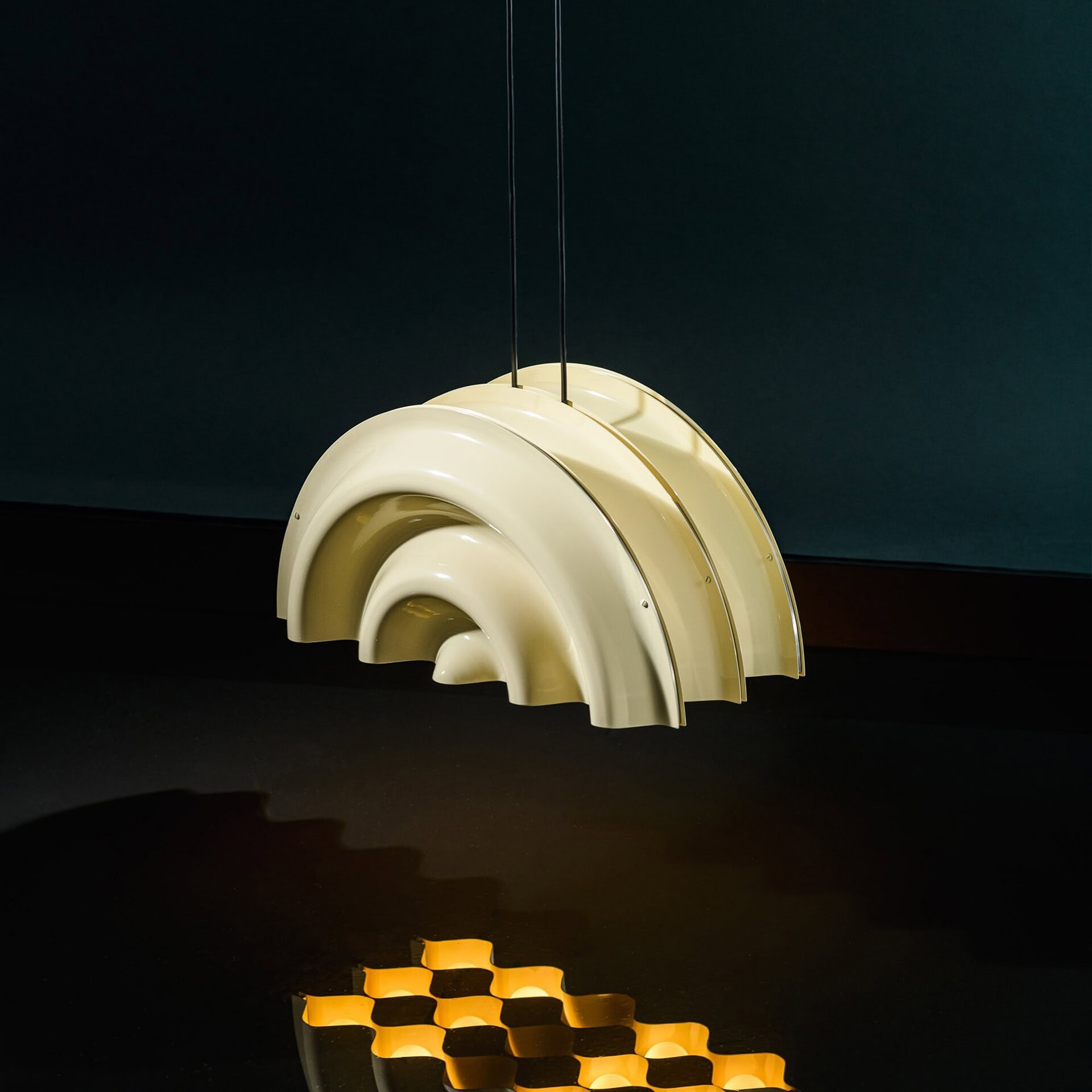 Shaker style cream pendant light hanging with reflection on black surface.