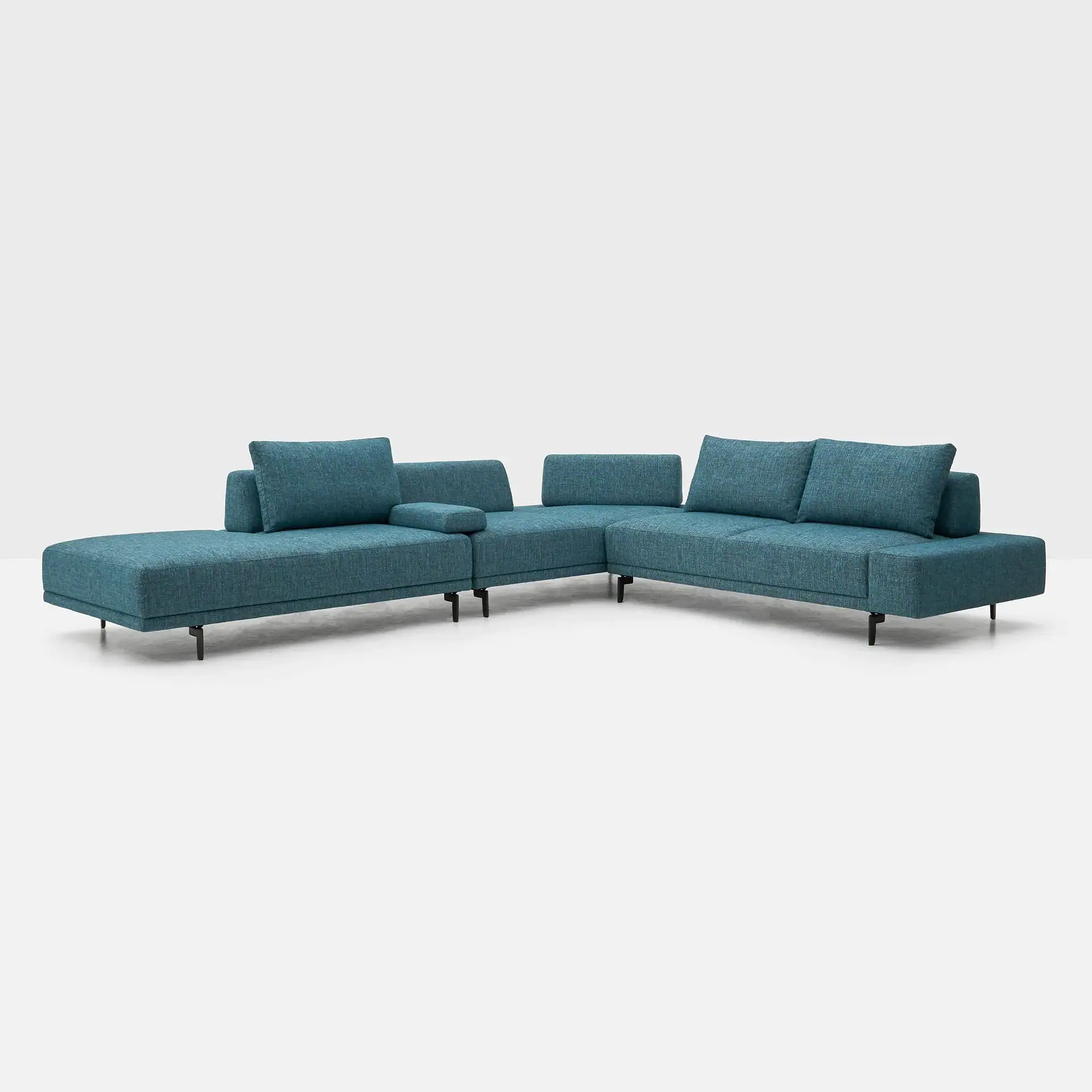 A teal modular sectional sofa with black legs on a light gray background.