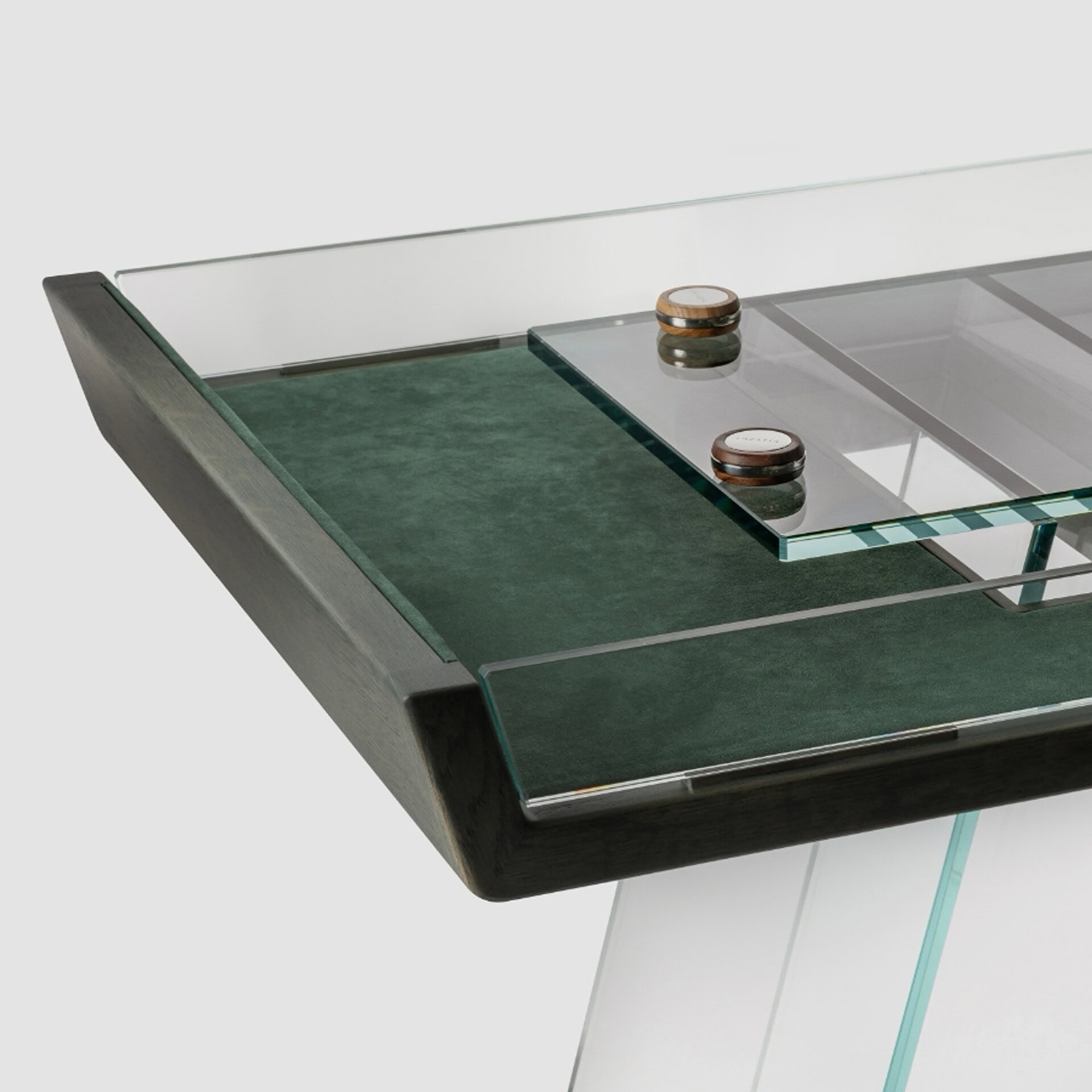 Sleek modern glass and wood coffee table with green felt accents, stylish and functional living room furniture.