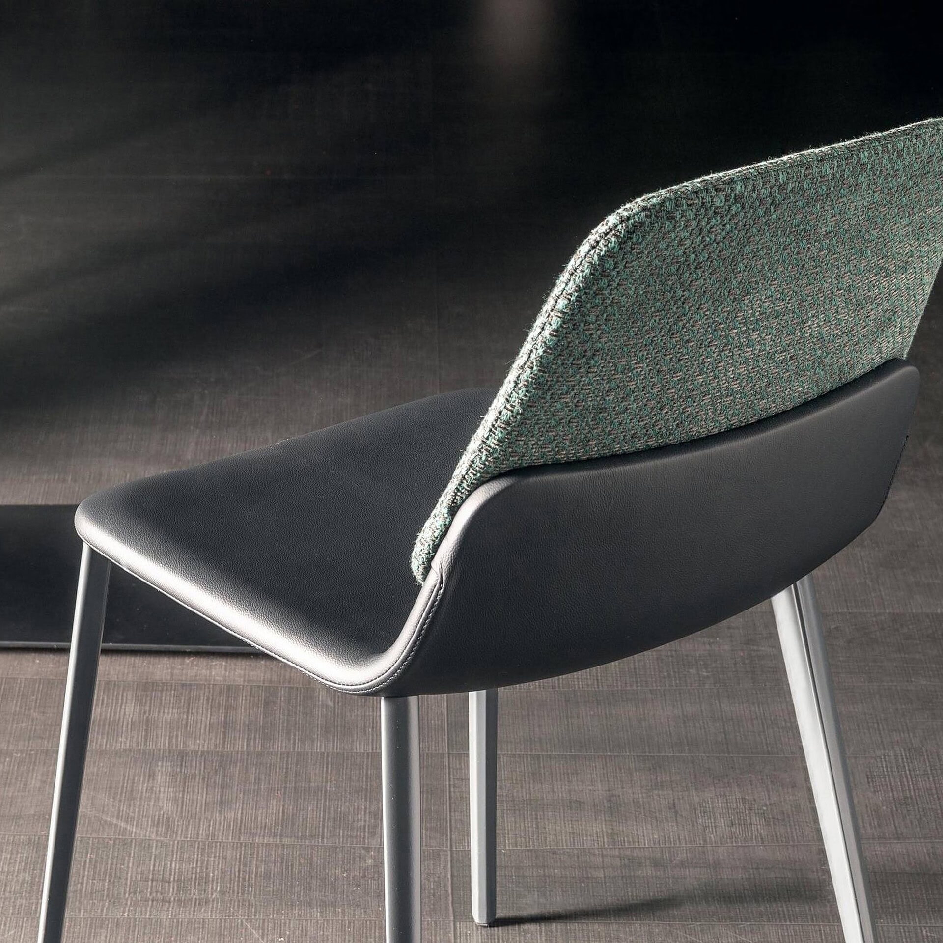 Sleek modern dining chair with upholstered fabric back and black cushioned seat, elegant design.