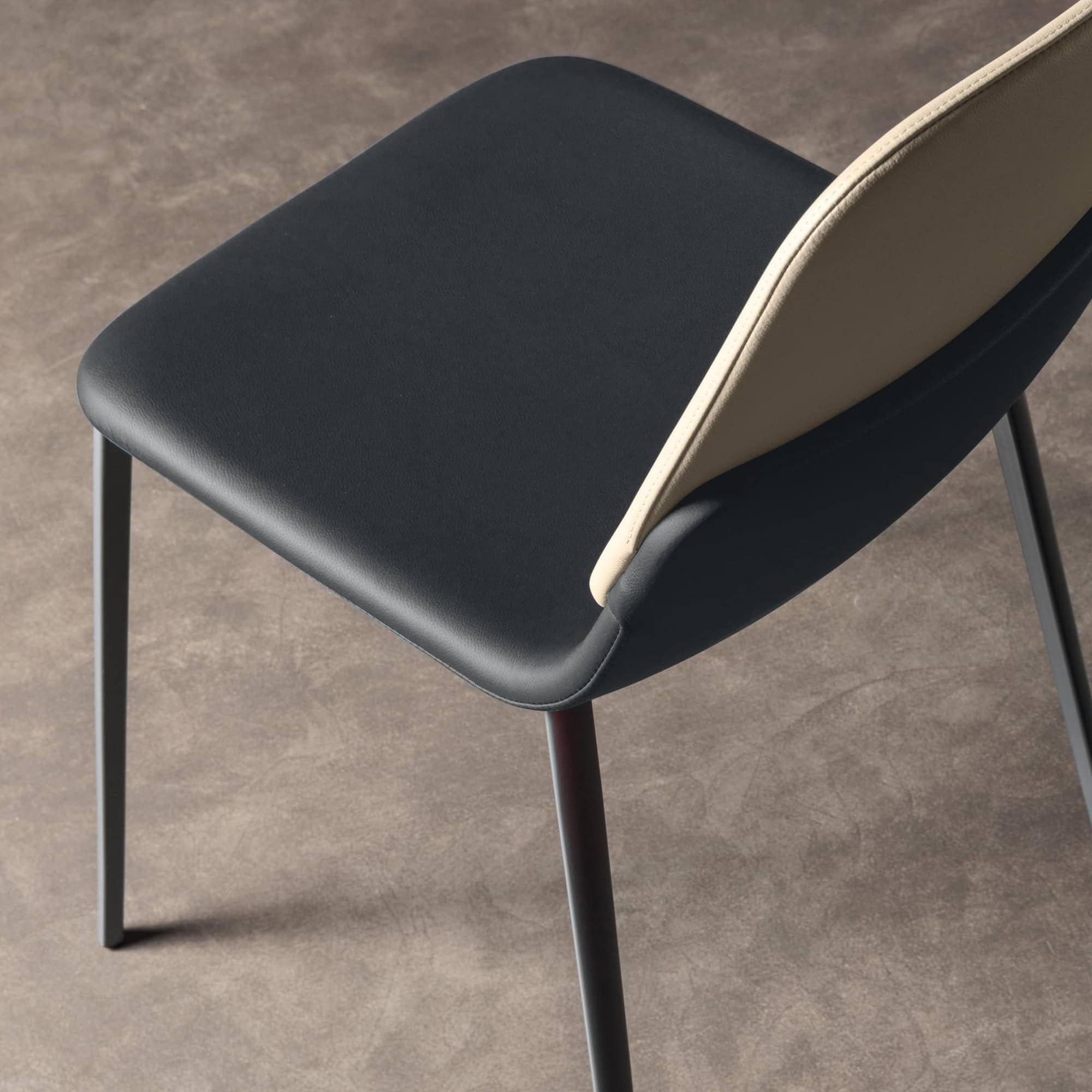 Contemporary black and beige dining chair with sleek metal legs, stylish and comfortable.