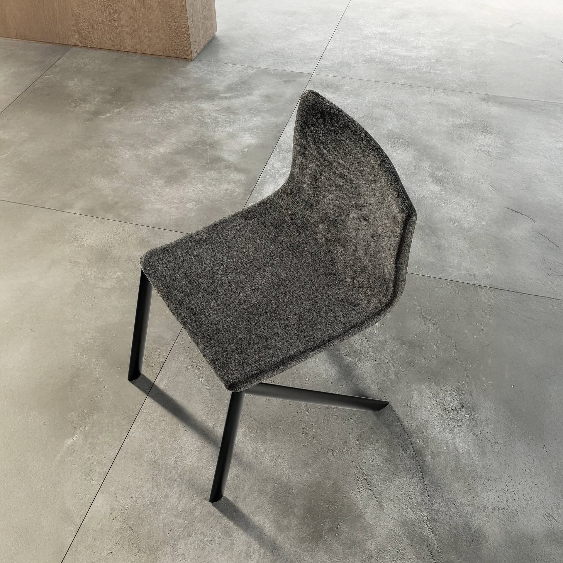 Contemporary dining chair with dark gray upholstery and sleek black legs.