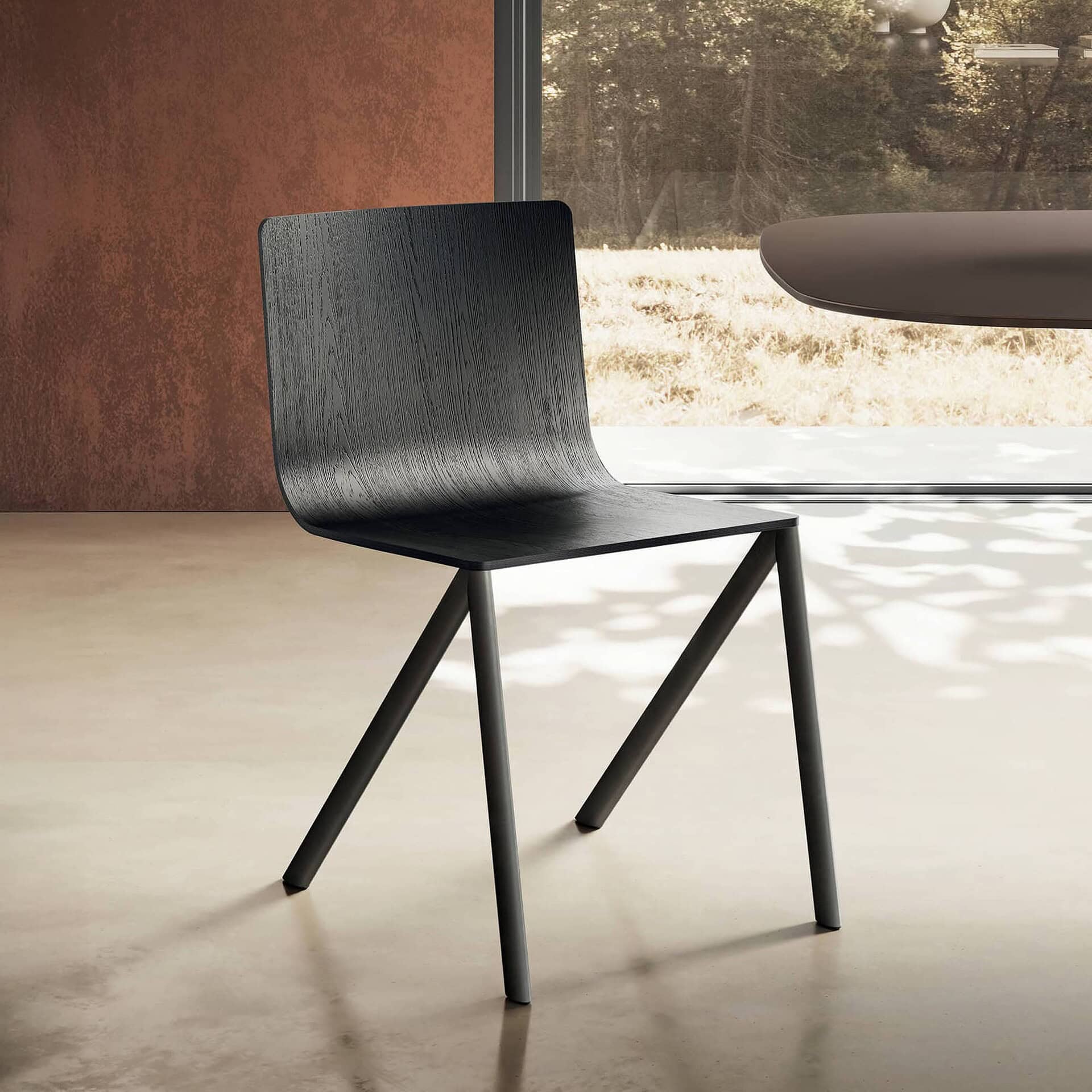 Black modern wooden dining chair with angled legs in a minimalist design.