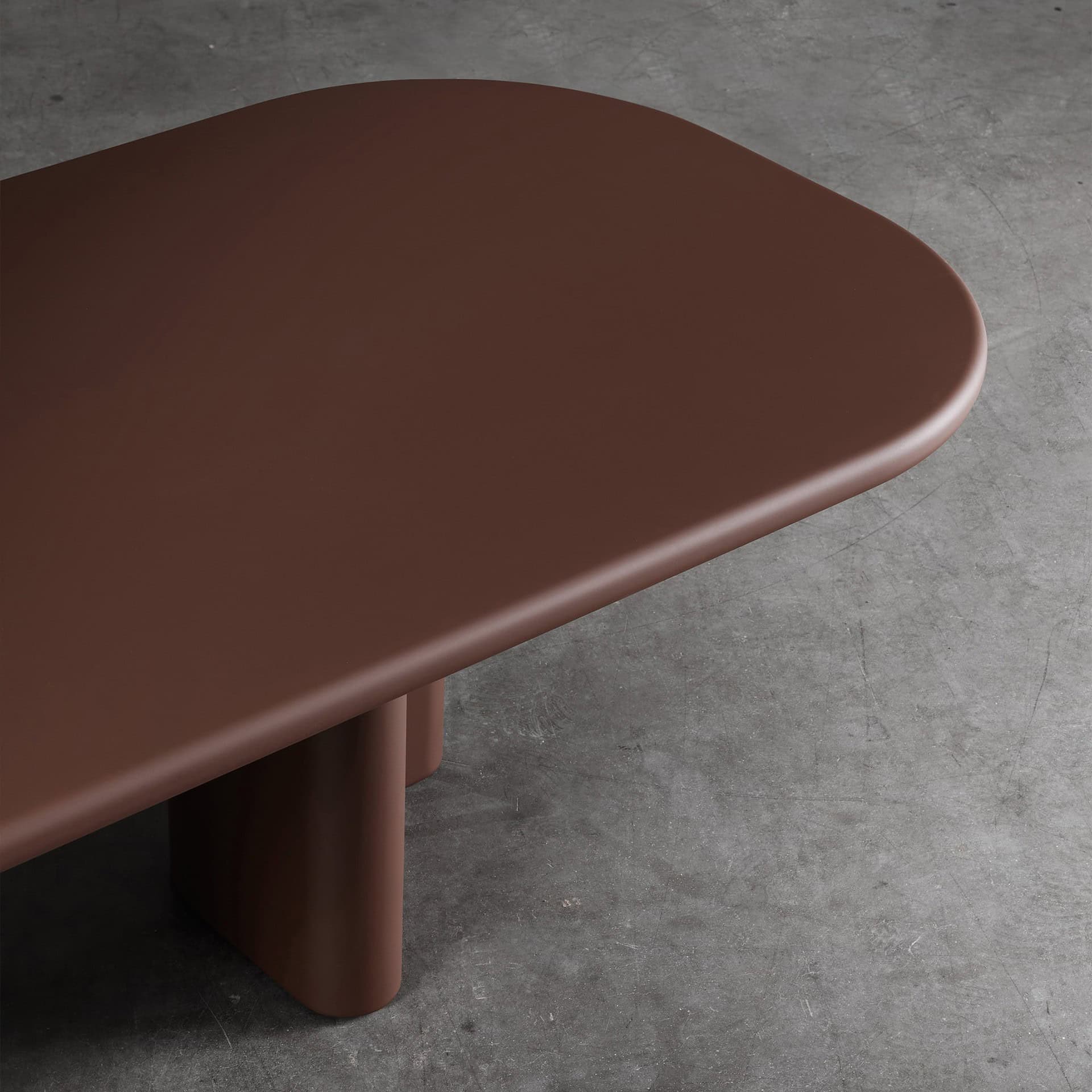 Smooth brown modern coffee table with rounded edges and sturdy cylindrical legs.