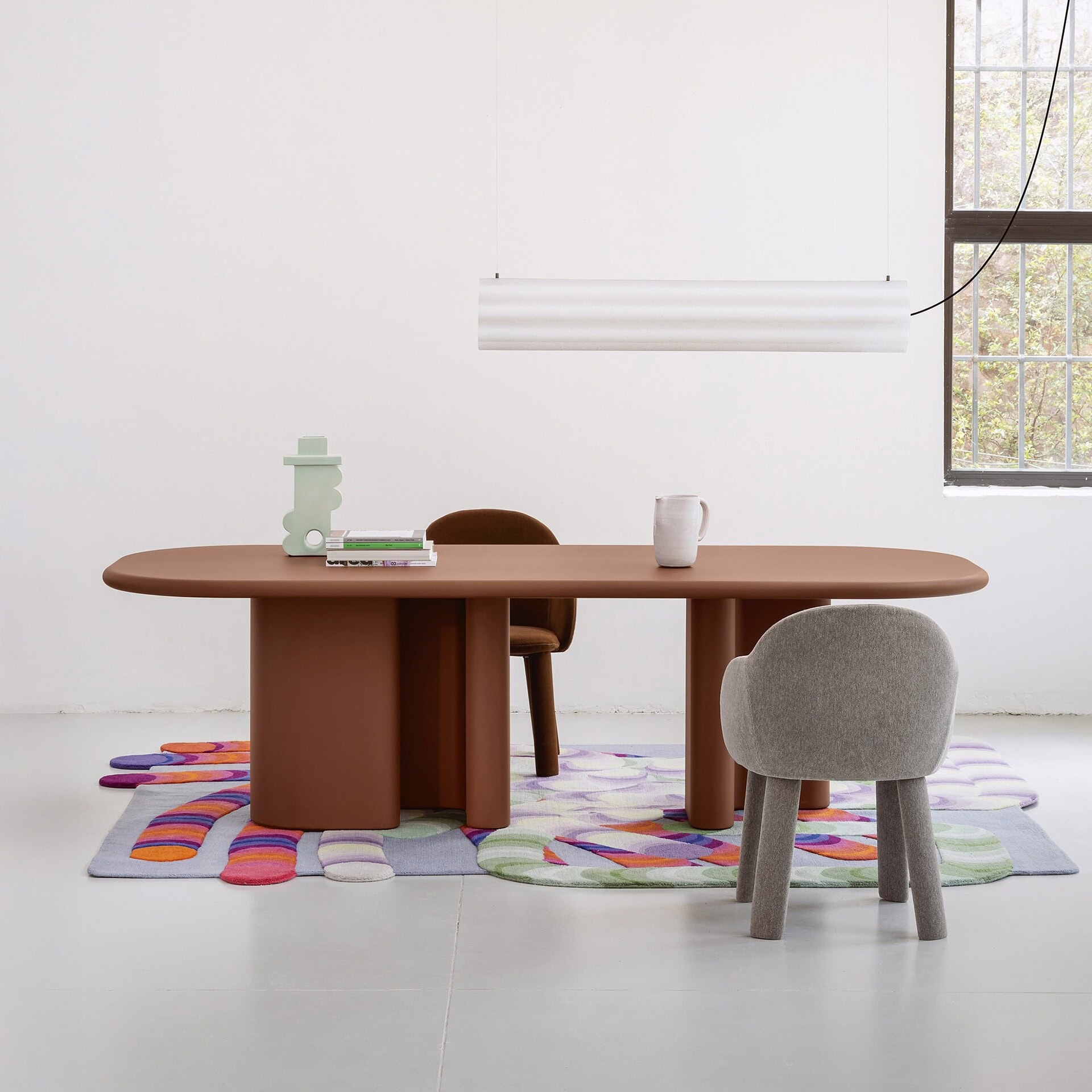 Modern minimalist dining table with colorful rug and contemporary chairs by Sklar Furnishings.