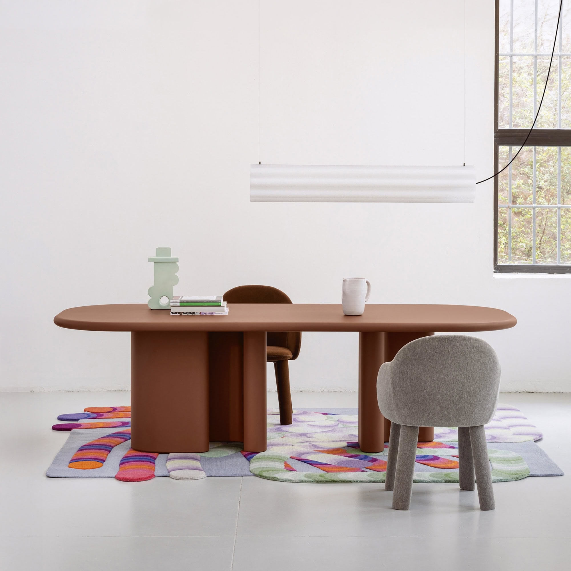 Modern minimalist dining table with colorful rug and contemporary chairs by Sklar Furnishings.