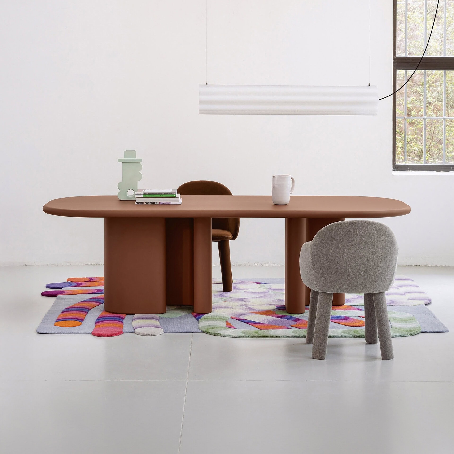 Modern minimalist dining table with colorful rug and contemporary chairs by Sklar Furnishings.