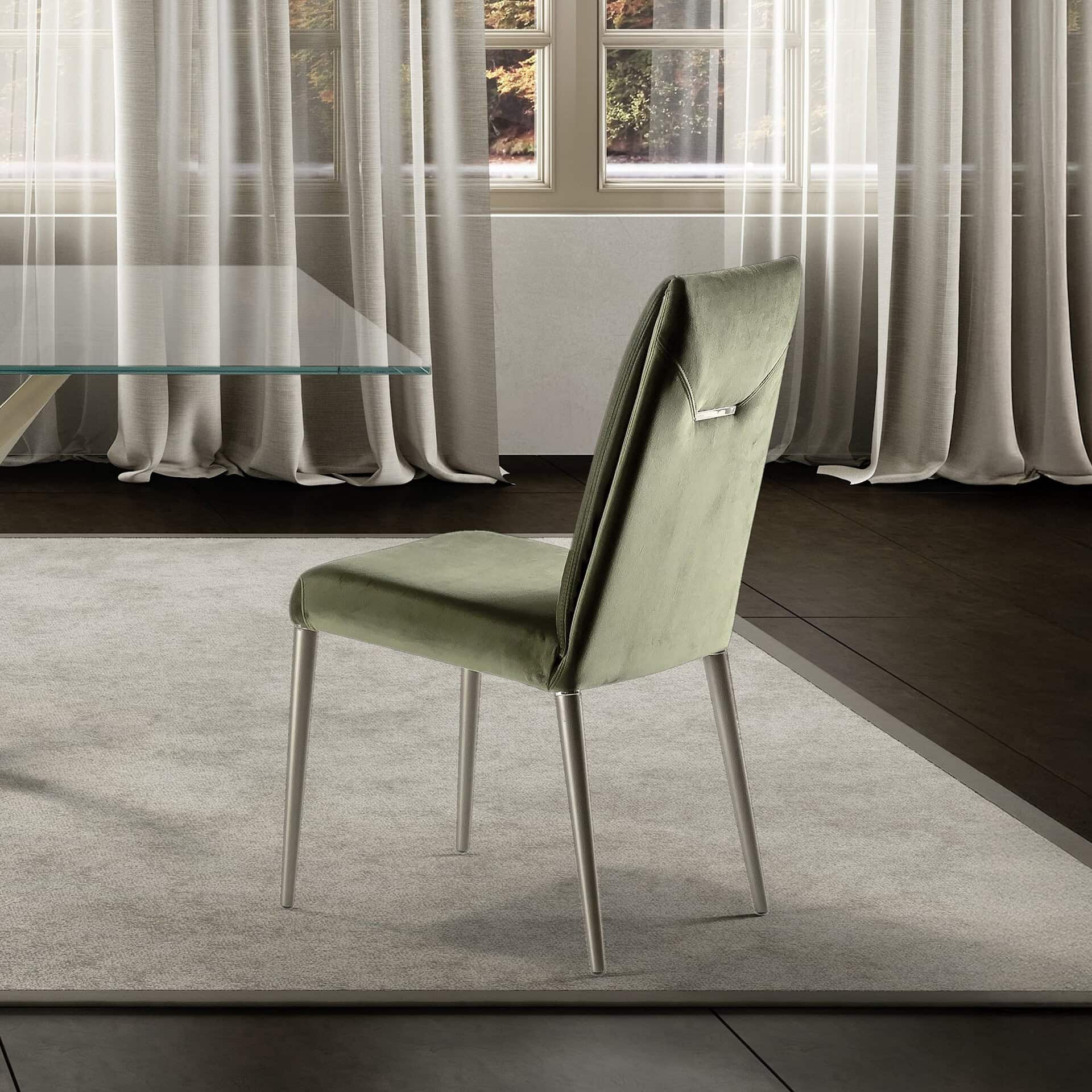 Elegant green upholstered dining chair in a contemporary home setting.